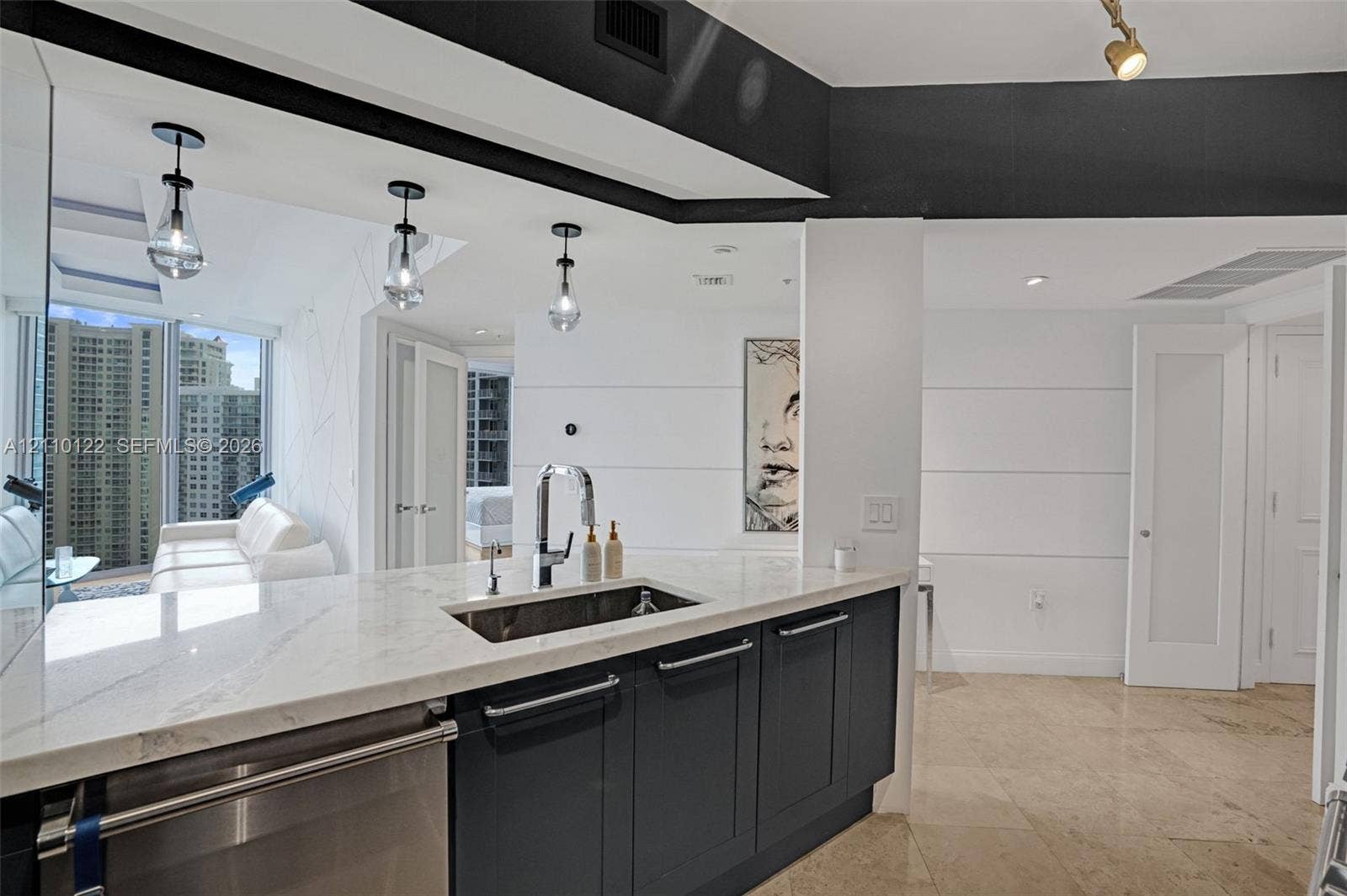 333 Las Olas Way, #2708, Fort Lauderdale, FL 33301 Kitchen featuring stone countertops, dark cabinetry, stainless steel undermount sink, pendant lighting, and polished stone flooring