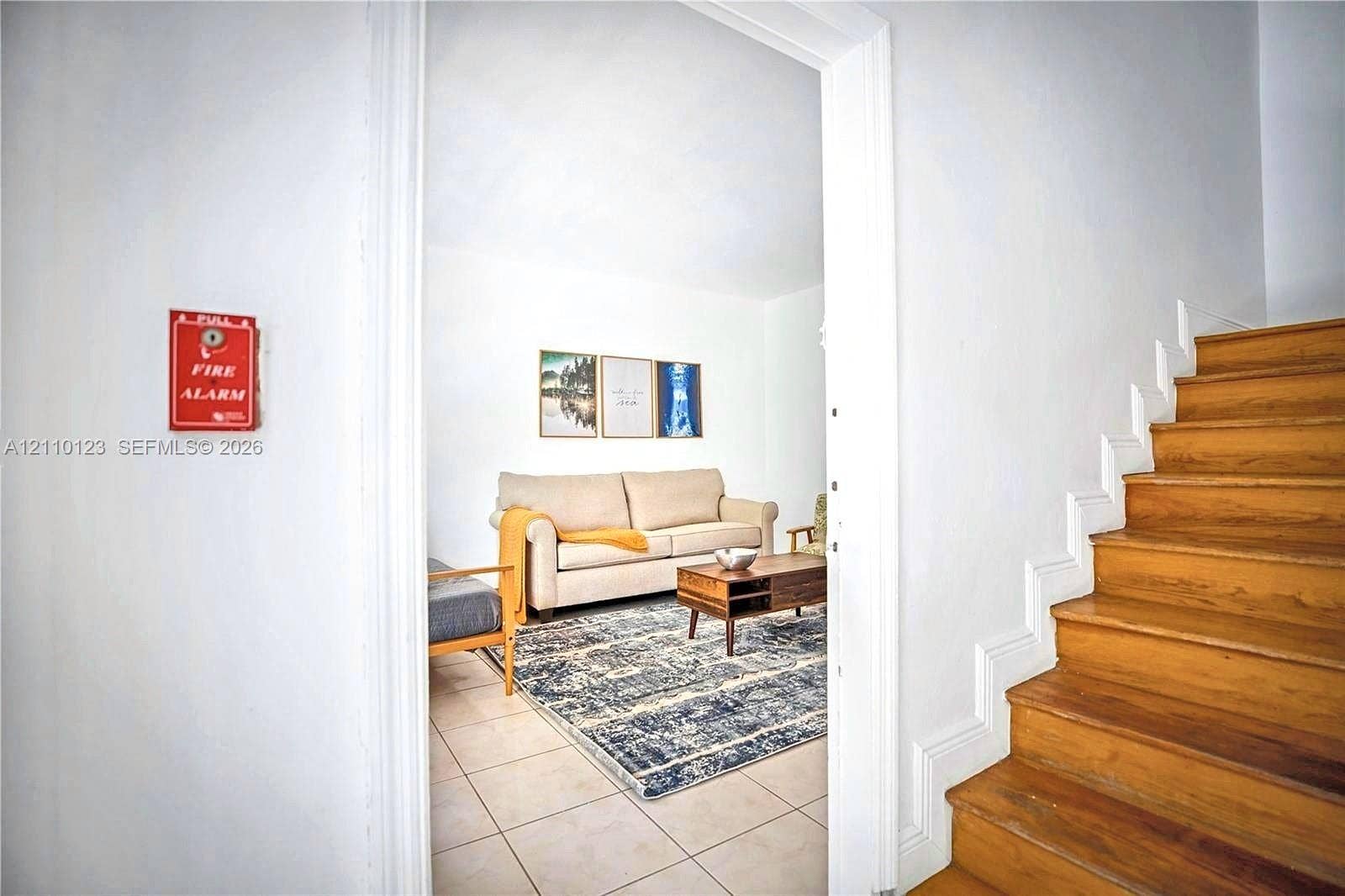 301 86th Street, #303-3, Miami Beach, Miami Beach, FL 33141 Staircase featuring wood-finish treads and white risers, accompanied by a fire alarm system