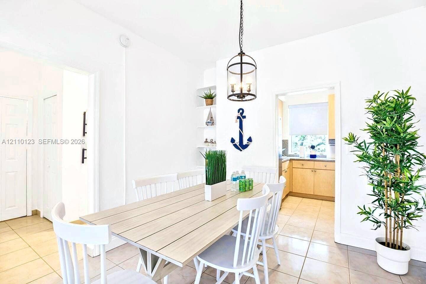 301 86th Street, #303-3, Miami Beach, Miami Beach, FL 33141 Dining area featuring large-format tile flooring, built-in recessed shelving, and a suspended iron-frame pendant light fixture