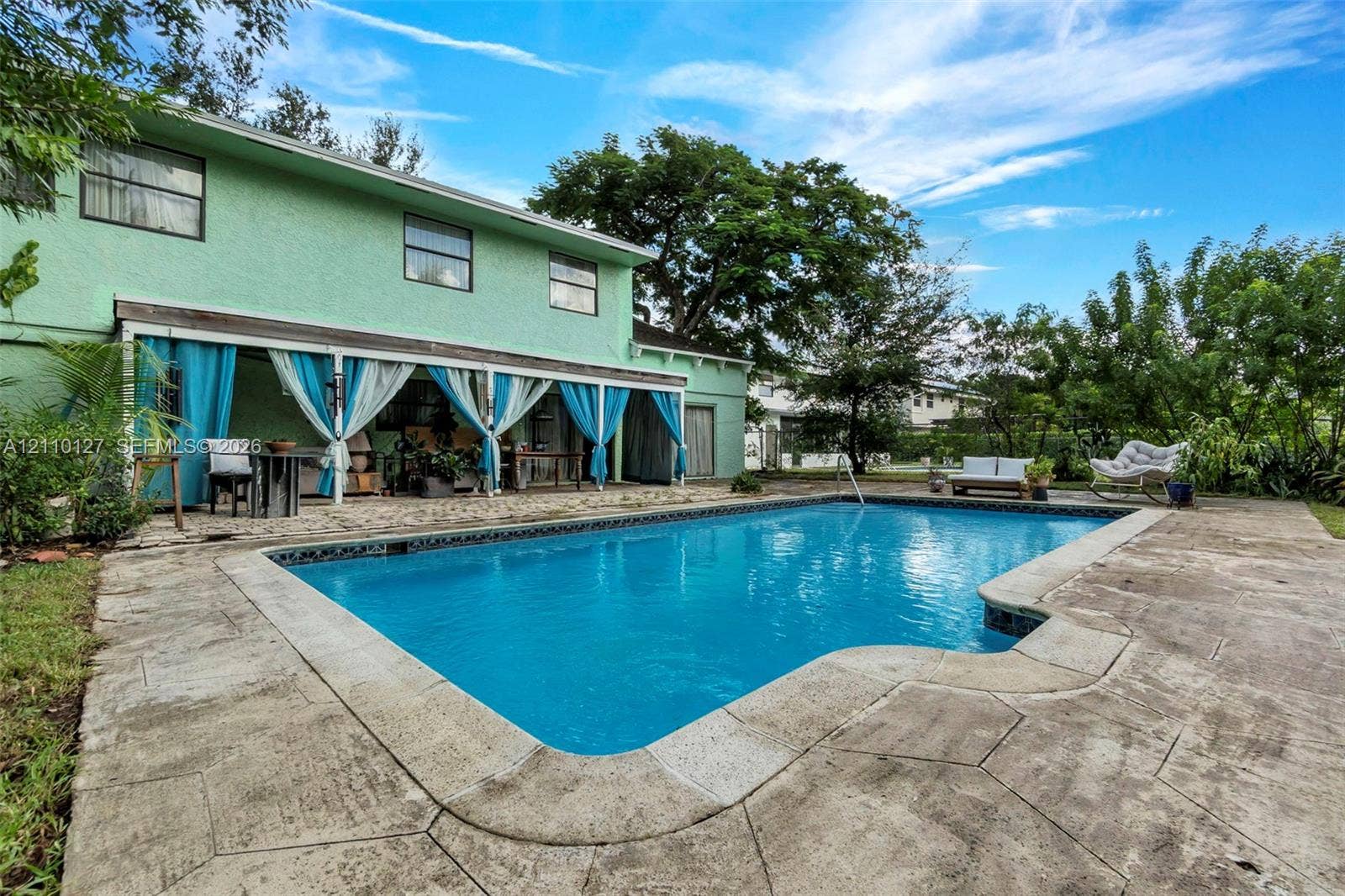 10164 SW 52nd Street, Cooper City, FL 33328 In-ground swimming pool featuring a concrete deck and a covered patio area with a support structure