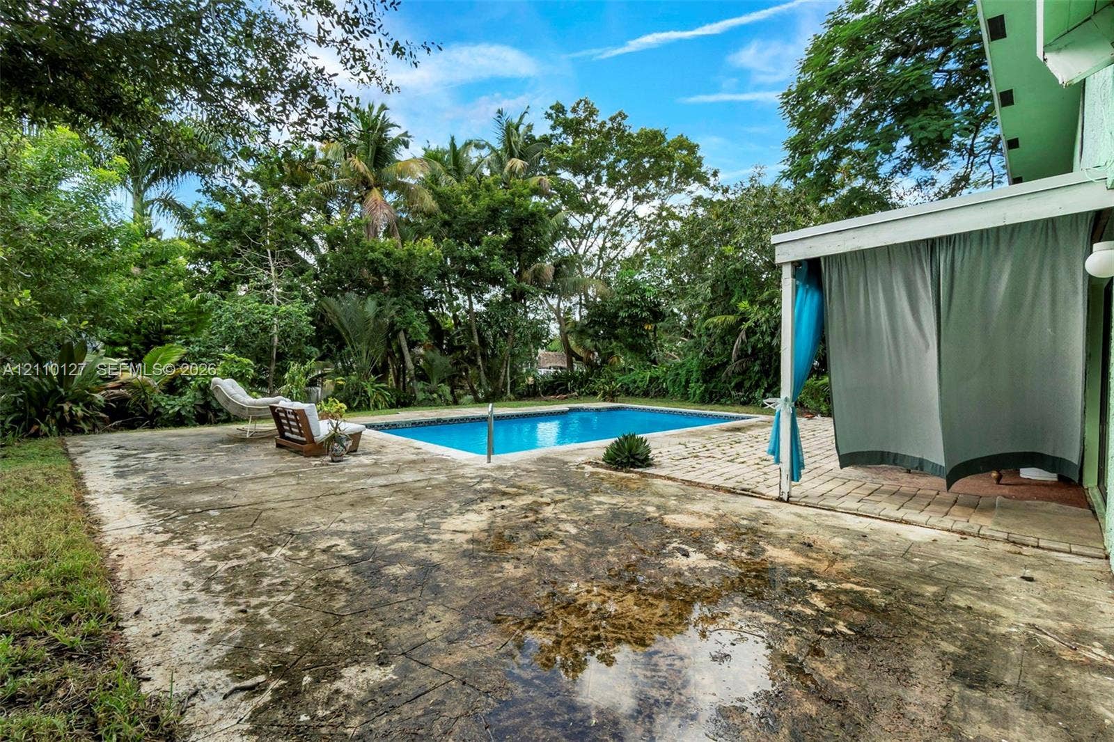 10164 SW 52nd Street, Cooper City, FL 33328 In-ground swimming pool featuring a concrete patio, covered porch area, and mature landscaping