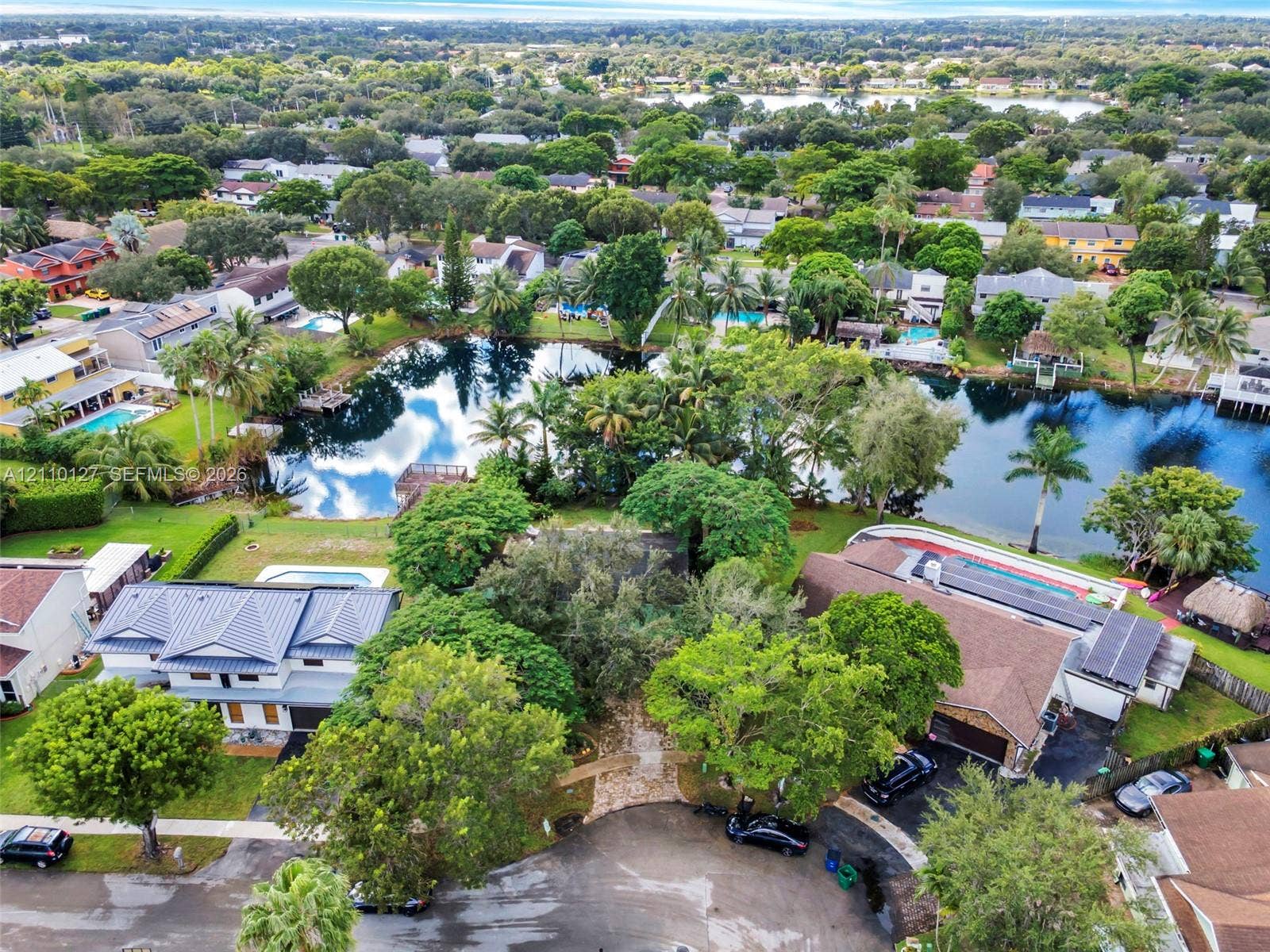 10164 SW 52nd Street, Cooper City, FL 33328 Aerial perspective featuring mature tree canopy, waterfront frontage, and established residential landscaping