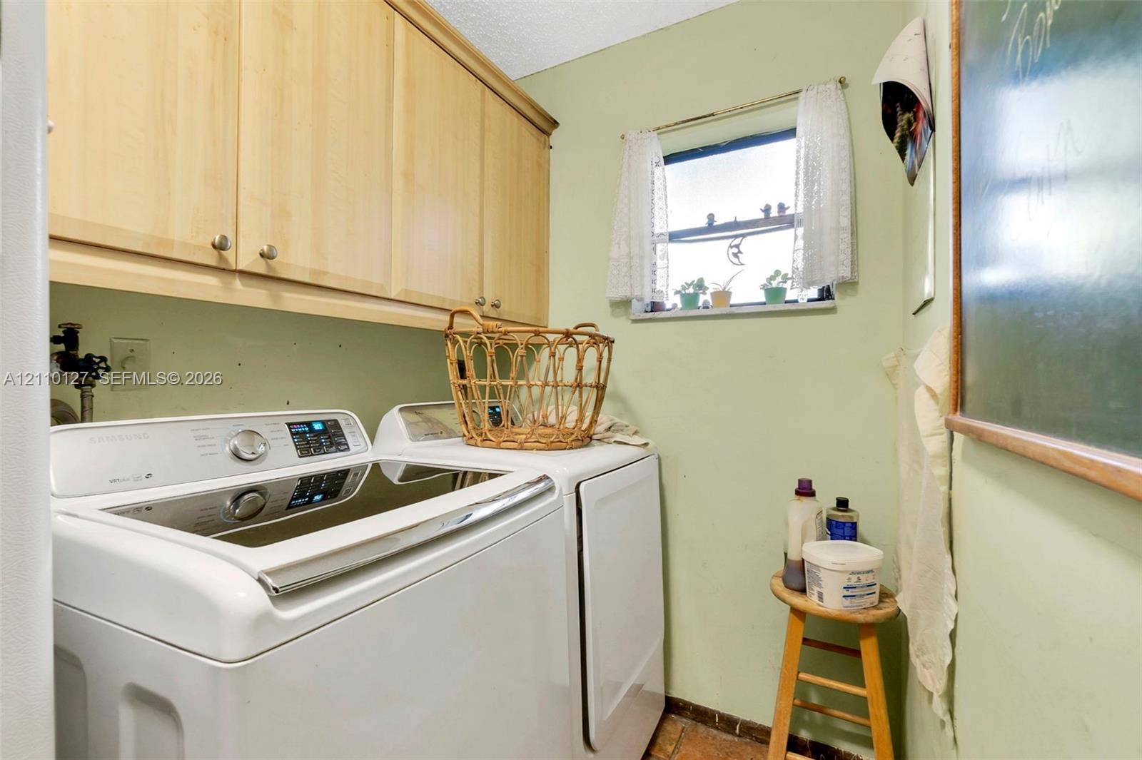 10164 SW 52nd Street, Cooper City, FL 33328 Laundry space featuring upper wood-finish cabinetry, a single-hung window, and dedicated plumbing connections