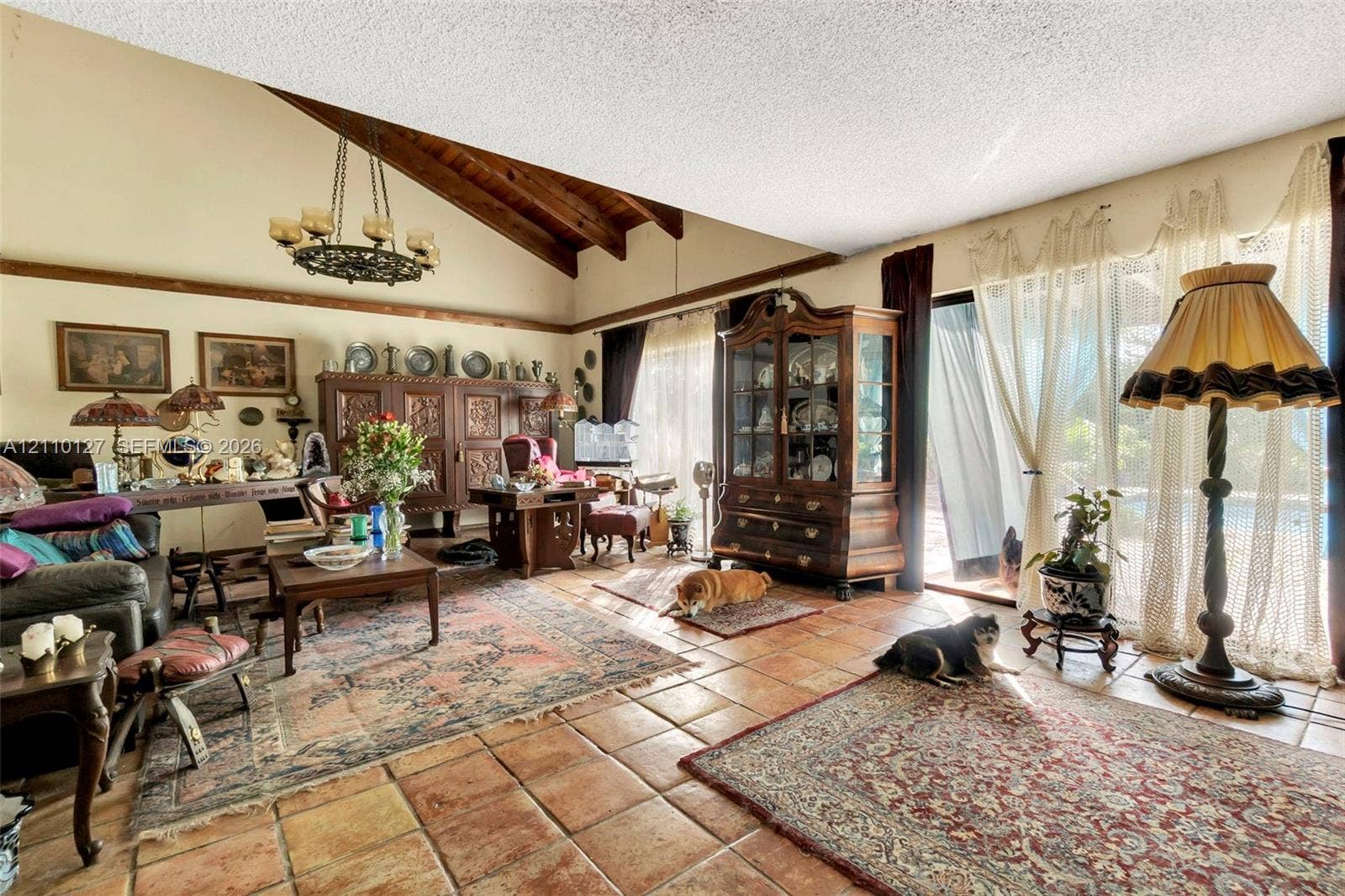 10164 SW 52nd Street, Cooper City, FL 33328 Living area featuring a vaulted ceiling with exposed wood beams, ceramic tile flooring, and sliding glass doors