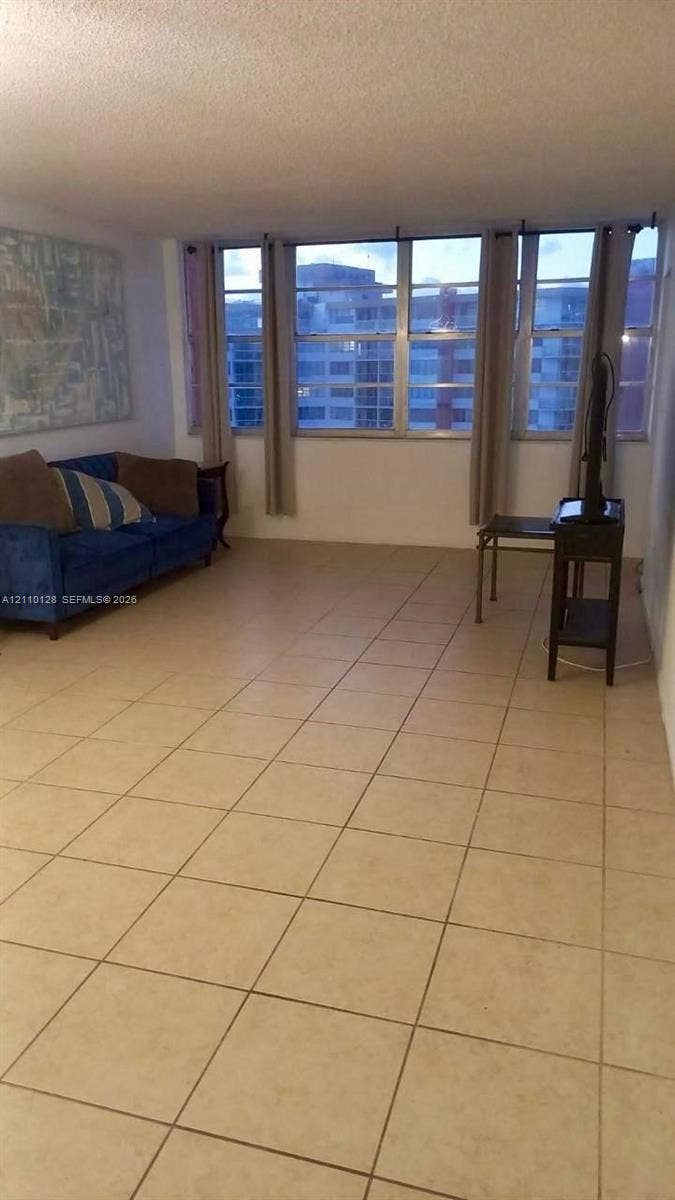 1351 NE Miami Gardens Drive, #1624E, Miami, FL 33179 Expansive living space featuring neutral square floor tiles and a wall of floor-to-ceiling windows