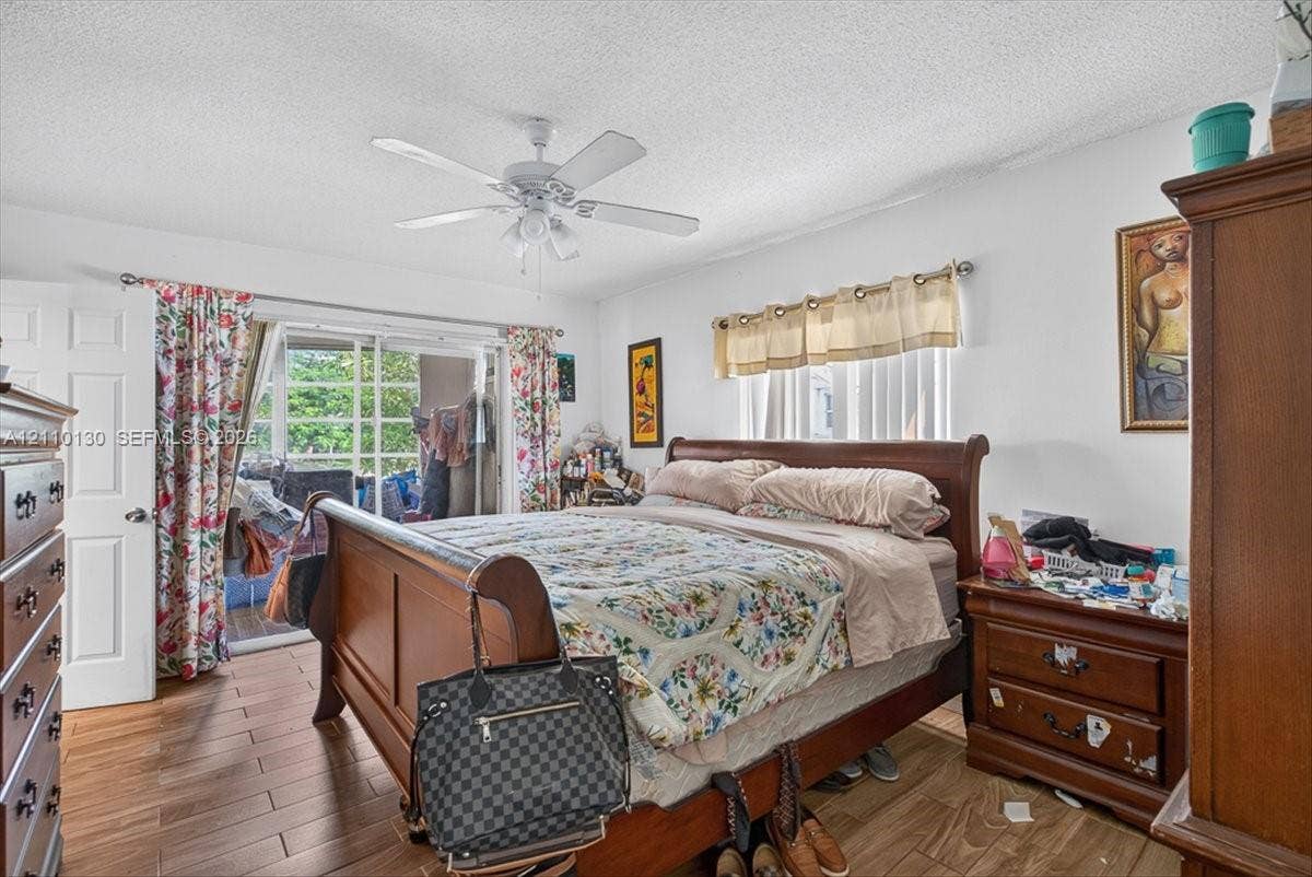 Wood-finish tile flooring, ceiling fan with integrated lighting, and sliding glass patio door