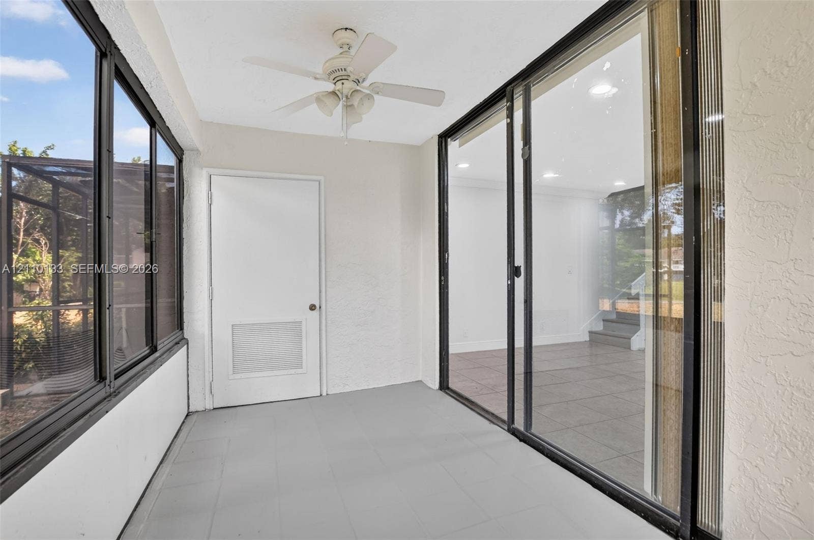 7890 Lago Del Mar Drive, #141, Boca Raton, Boca Raton, FL 33433 Enclosed porch featuring tile flooring, metal-framed screen wall panels, integrated ceiling fan, and sliding glass panel doors