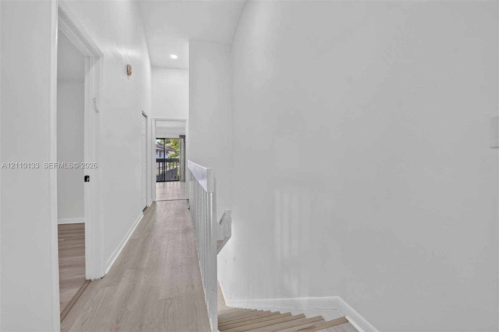 7890 Lago Del Mar Drive, #141, Boca Raton, Boca Raton, FL 33433 Hallway featuring wood-finish flooring, vaulted ceilings, recessed lighting, and a white balustrade railing