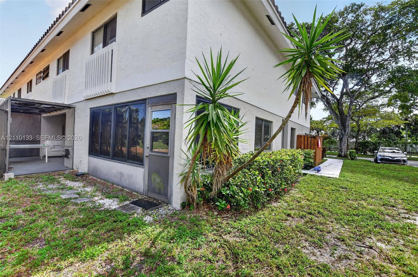 7890 Lago Del Mar Drive, #141, Boca Raton, Boca Raton, FL 33433 Two-story exterior with stucco finish, enclosed patio, and mature landscaping