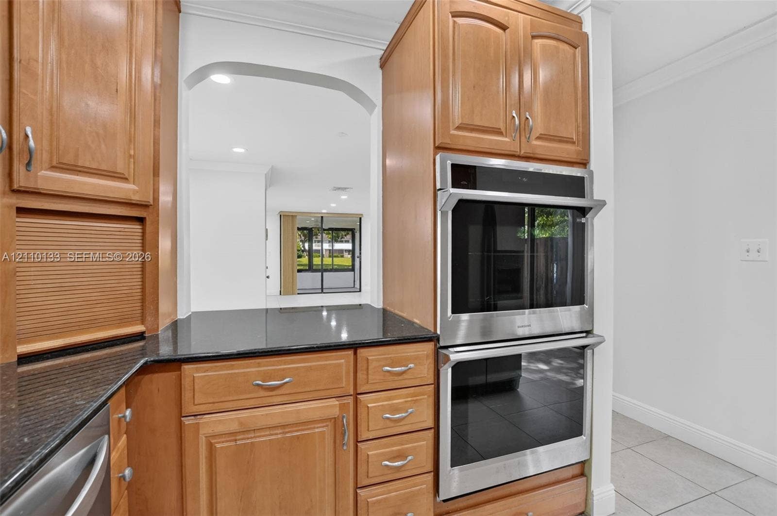 7890 Lago Del Mar Drive, #141, Boca Raton, Boca Raton, FL 33433 Kitchen featuring wood cabinetry, integrated double wall ovens, dark stone countertops, and crown molding