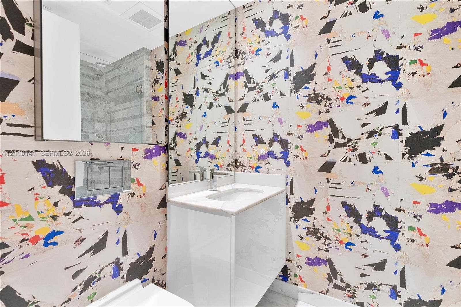 10203 Collins Avenue, #303, Bal Harbour, FL 33154 Designer Wall Covering ,Modern floating vanity with a white countertop and basin, wall-mounted chrome faucet, and expansive wall-to-wall mirror /guest bathrroom