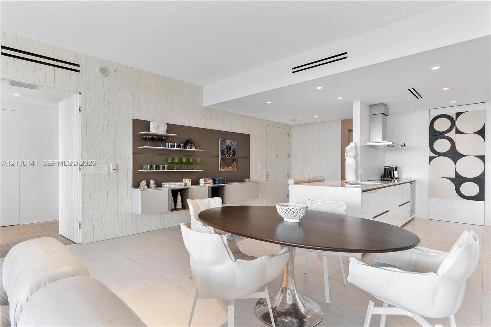 10203 Collins Avenue, #303, Bal Harbour, FL 33154 Open-concept interior, recessed ceiling lighting, a kitchen island with stone countertops, and built-in wall cabinetry