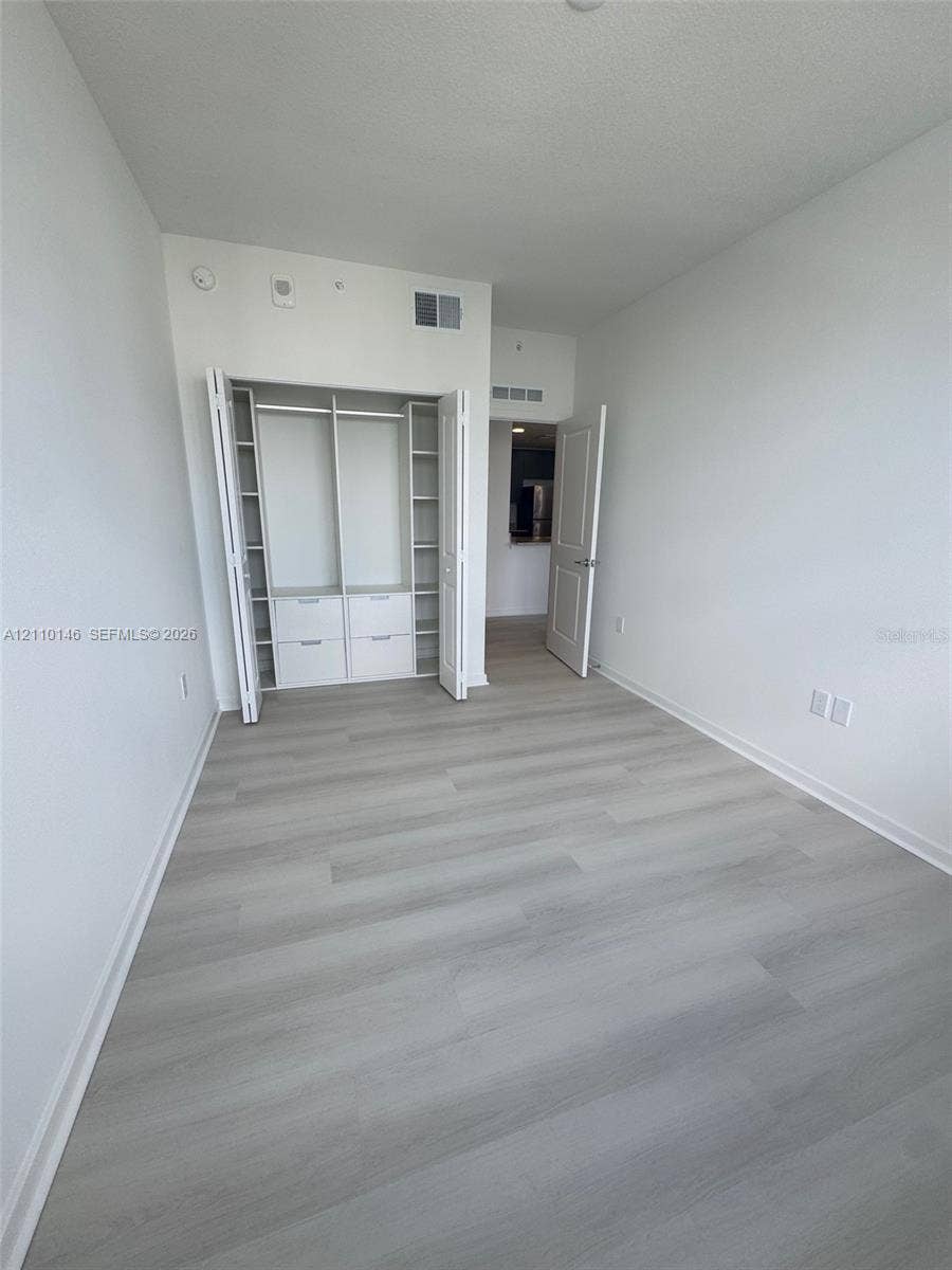 5563 Millenia Park Boulevard, #427, Orlando, Orlando, FL 32839 Interior space featuring wood-finish flooring and a built-in closet system with integrated shelving and drawer storage