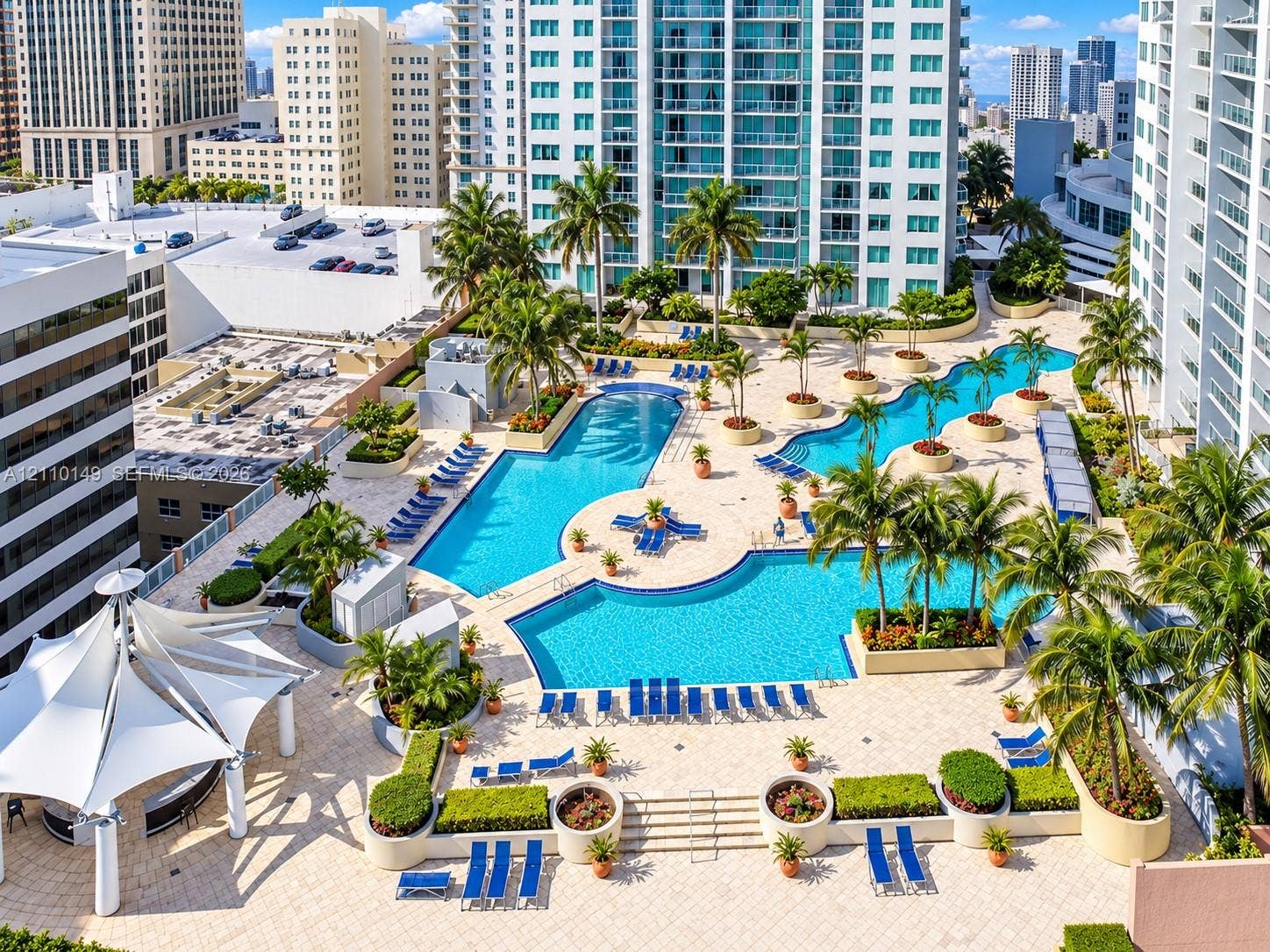 Multi-level swimming pools with hardscaped pool deck, palm tree landscaping, built-in structural planters, and tensile fabric shade structure