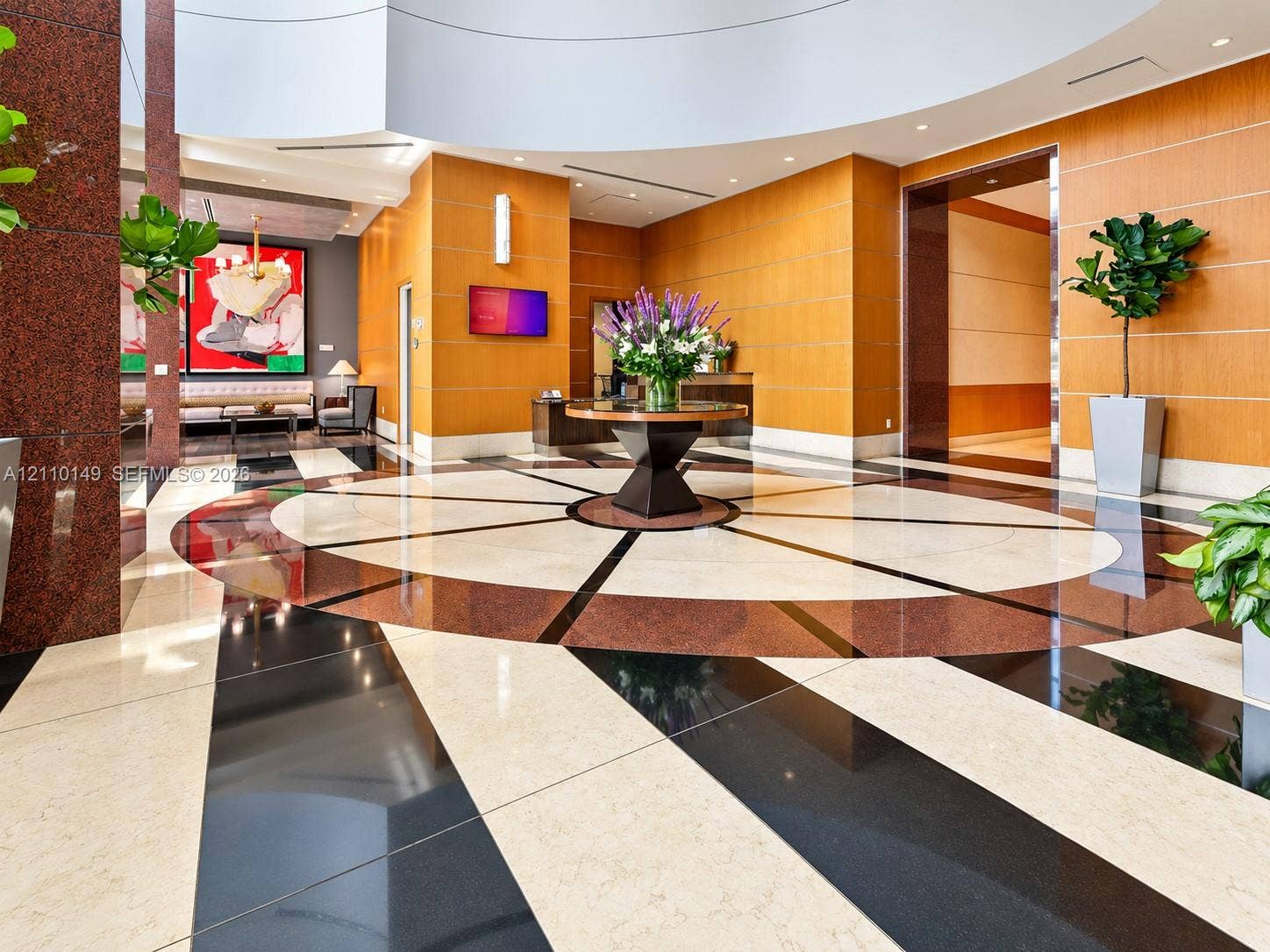 Grand lobby featuring a high, circular coffered ceiling, polished multi-toned stone flooring, and warm-toned paneled walls
