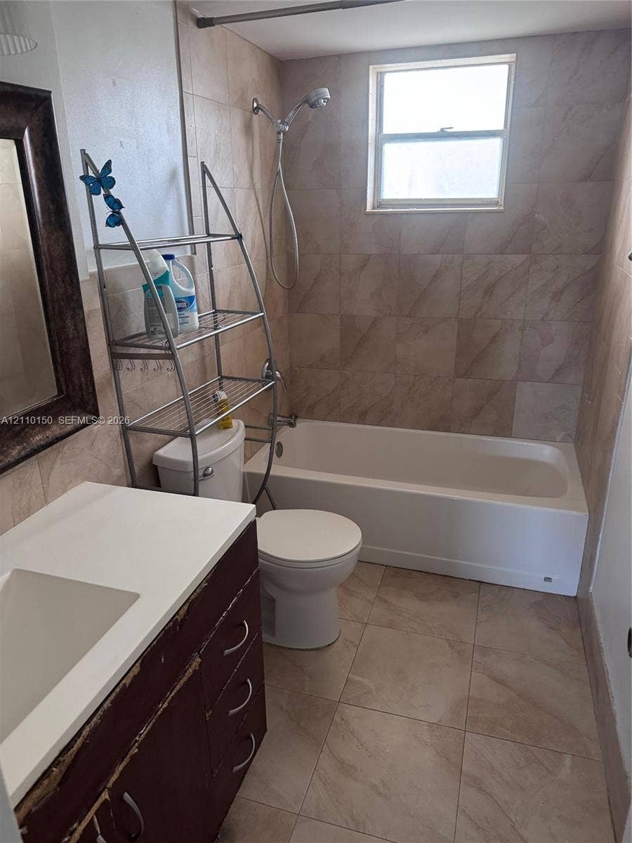 20111 NE 27th Court, #K212, Aventura, Aventura, FL 33180 Bathroom featuring neutral-toned tile flooring, tub-shower combination with tiled surround, and vanity with a solid surface countertop