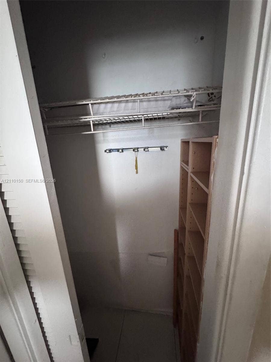 20111 NE 27th Court, #K212, Aventura, Aventura, FL 33180 Storage area featuring wire shelving, a mounted hardware rack, and built-in vertical wooden shelving units