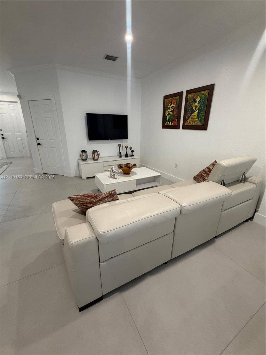 Neutral tile flooring, recessed lighting, and solid-core interior doors
