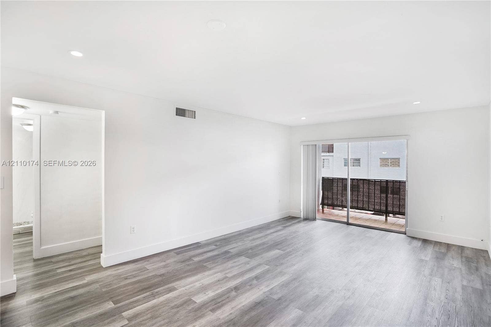 Interior space featuring wood-finish flooring, recessed lighting, and sliding glass doors with access to an exterior balcony