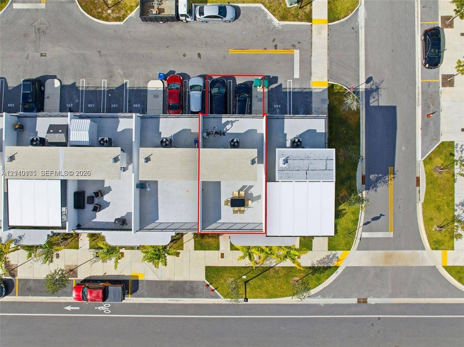 26122 SW 145th Court, #26122, Homestead, Homestead, FL 33032 Aerial perspective of a multi-level property featuring a rooftop terrace, designated surface parking, and exterior lighting fixtures