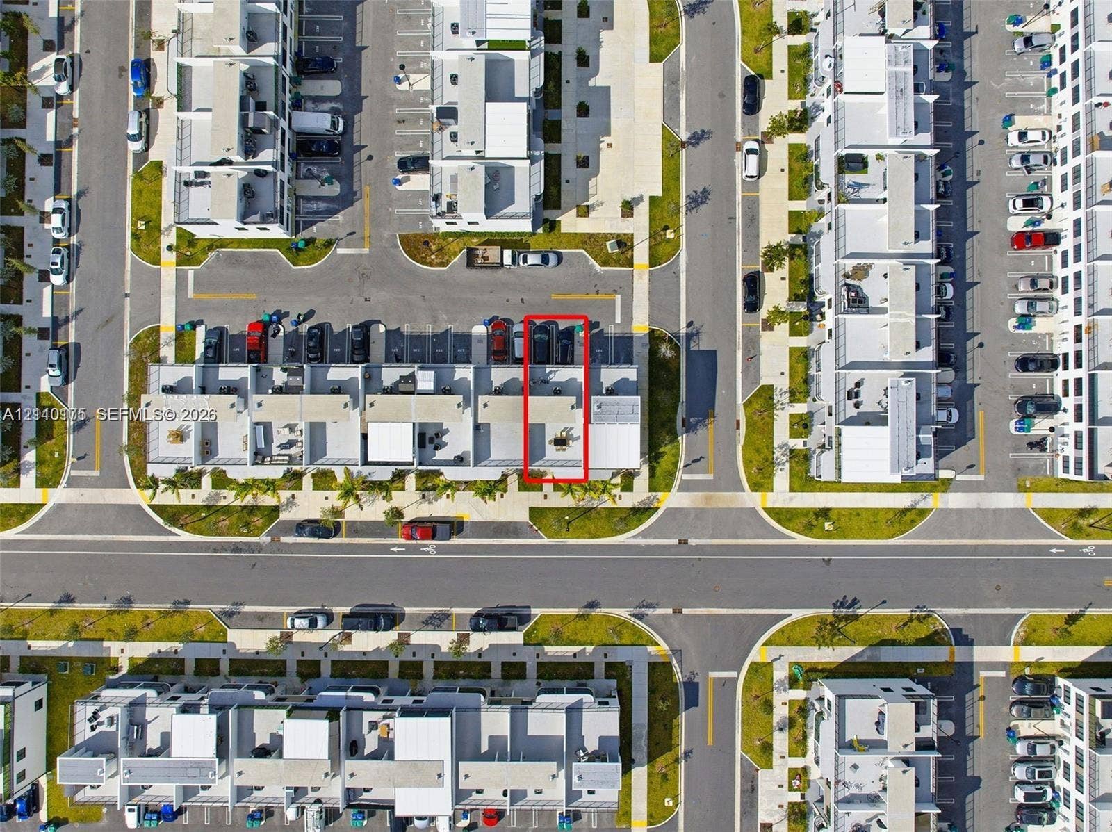 26122 SW 145th Court, #26122, Homestead, Homestead, FL 33032 Aerial view of a residential unit featuring a paved rear patio, designated parking spaces, and proximity to internal roadways within the community