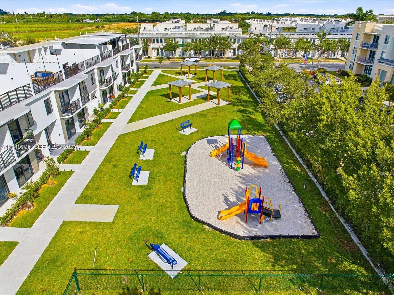 26122 SW 145th Court, #26122, Homestead, Homestead, FL 33032 Community grounds featuring a playground, multiple shaded pergolas, concrete walking paths, and expansive green space