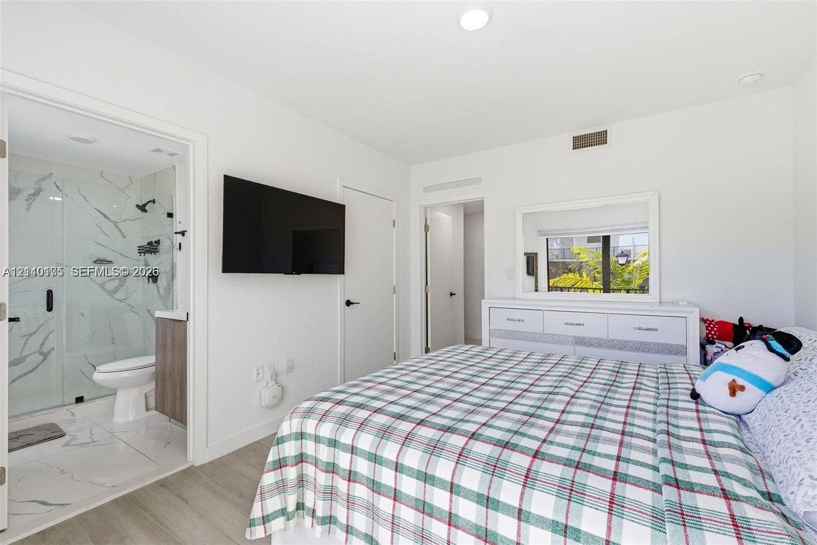 26122 SW 145th Court, #26122, Homestead, Homestead, FL 33032 Bedroom featuring wood-finish flooring, recessed lighting, and a private bath with a glass-enclosed shower featuring large-format veined tile and a floating vanity