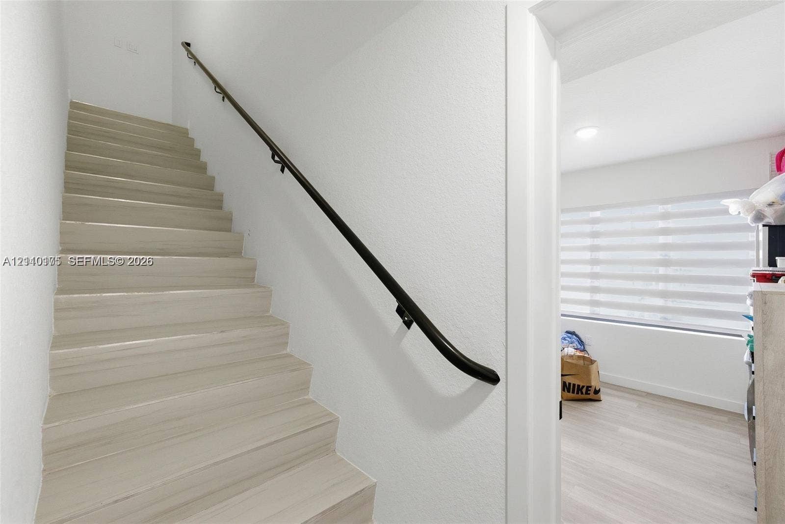 26122 SW 145th Court, #26122, Homestead, Homestead, FL 33032 Staircase featuring light wood-finish treads and a matte black wall-mounted handrail