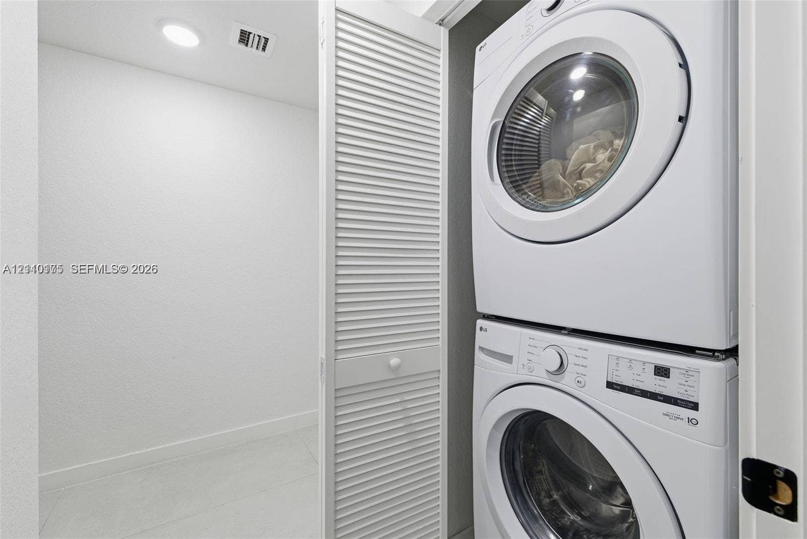 26122 SW 145th Court, #26122, Homestead, Homestead, FL 33032 Laundry closet featuring stacked front-load appliances and louvered folding doors