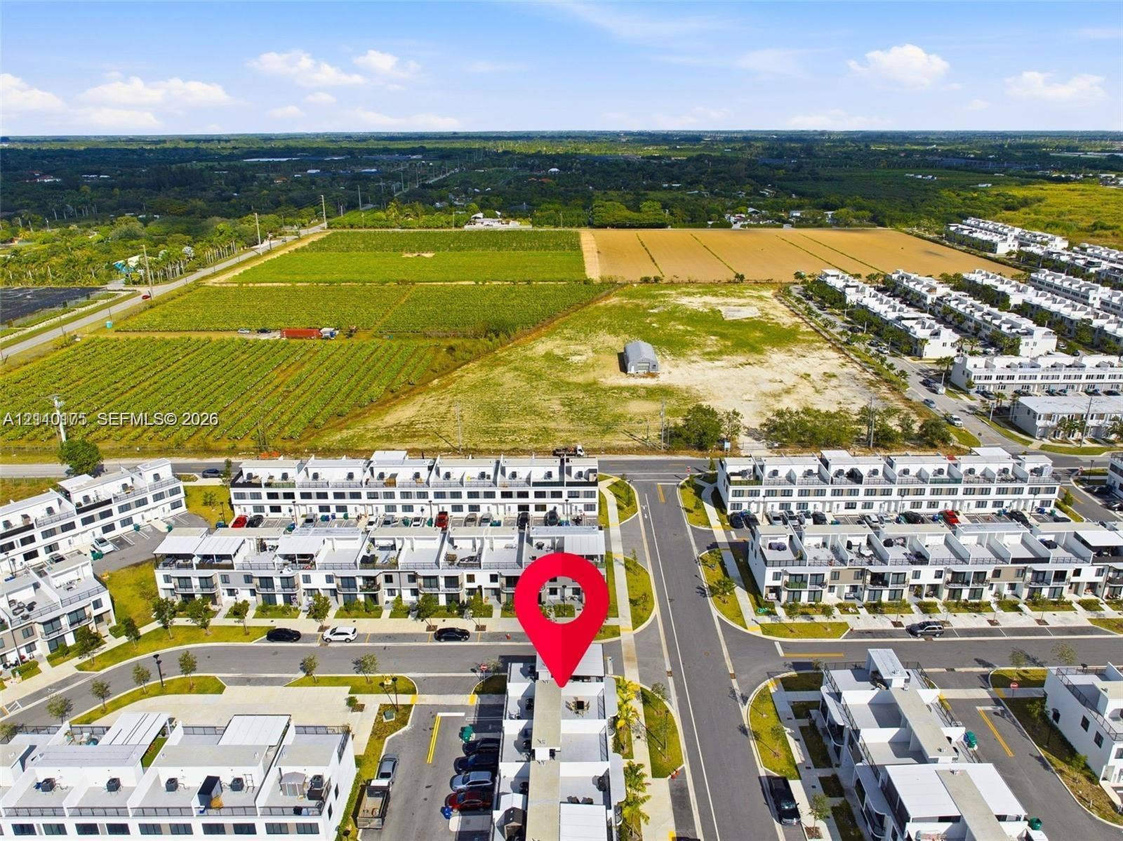 26122 SW 145th Court, #26122, Homestead, Homestead, FL 33032 Aerial perspective of a multi-story residential community featuring paved street infrastructure and designated surface parking