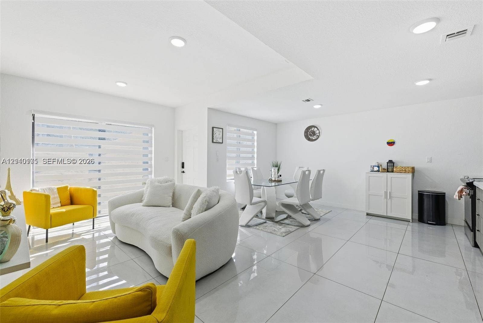26122 SW 145th Court, #26122, Homestead, Homestead, FL 33032 Open-concept interior featuring large-format ceramic tile flooring, recessed lighting, and expansive glass sliding doors with integrated horizontal window treatments