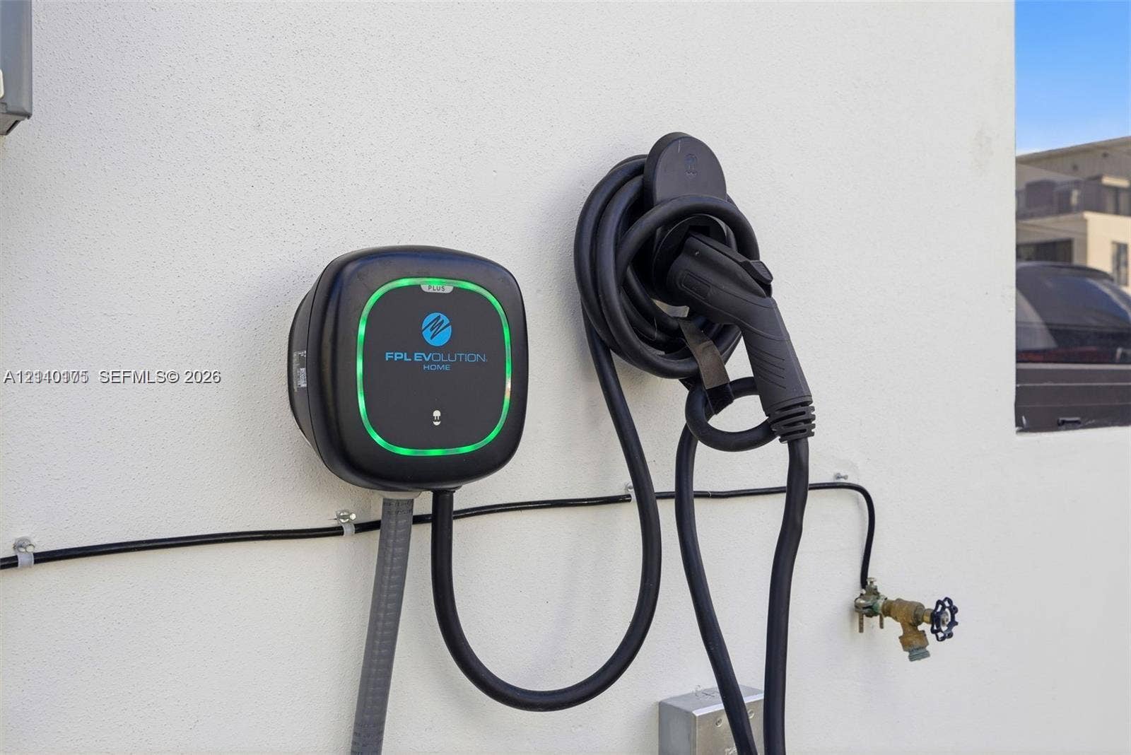 26122 SW 145th Court, #26122, Homestead, Homestead, FL 33032 Wall-mounted electric vehicle charging station featuring a dedicated charging unit, coiled cord, and handle