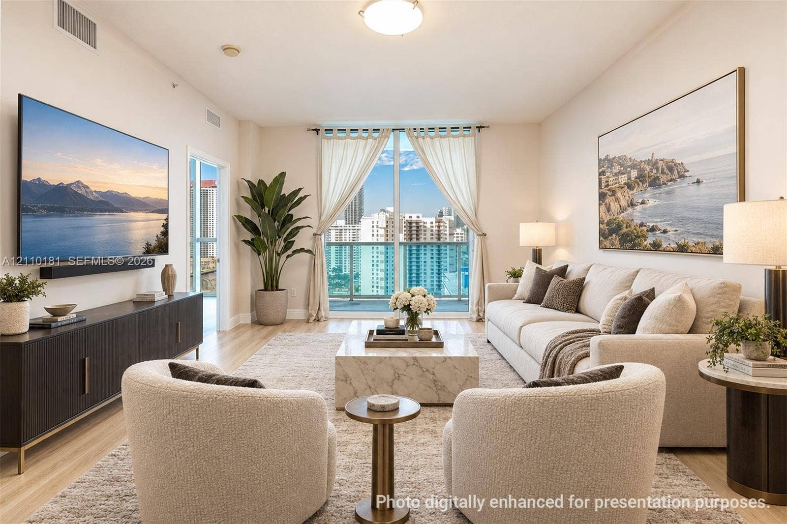 Living area featuring high ceilings, wood-finish flooring, and a glass door providing access to a private balcony with an urban backdrop