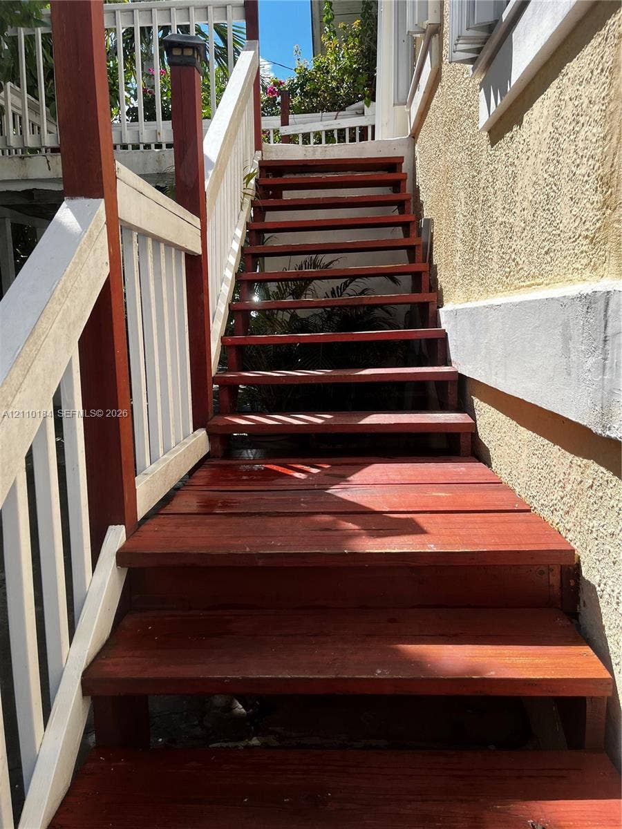 Exterior staircase featuring wood treads and a painted white wooden railing