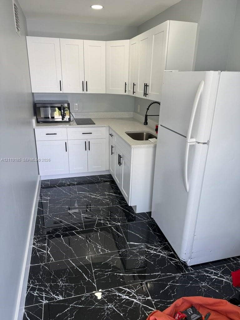 2596 Rosehaven Road, #2, West Palm Beach, West Palm Beach, FL 33415 Kitchen featuring white shaker-style cabinetry, quartz countertops, high-contrast dark stone-finish flooring, and a matte black pull-down faucet