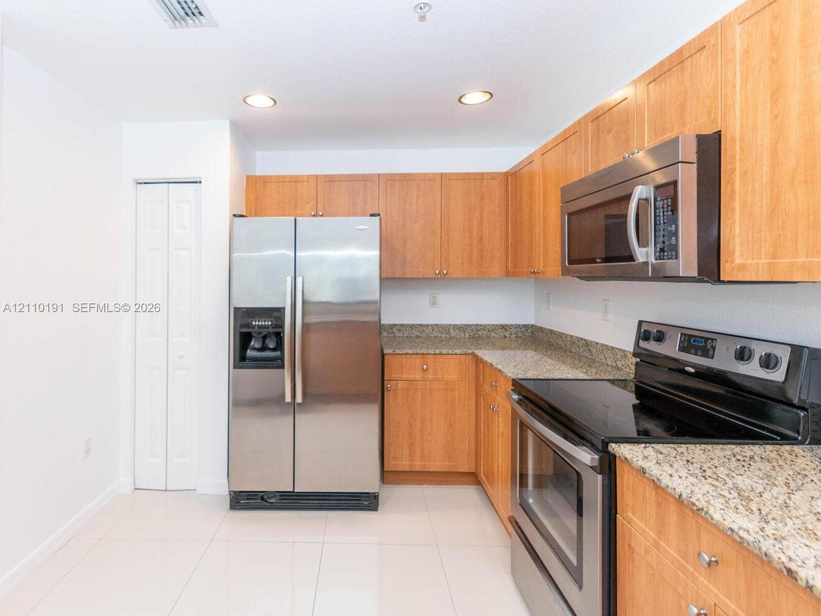 8999 NW 107 Court, #218-1, Miami, Miami, FL 33178 Kitchen featuring wood cabinetry, stone countertops, stainless steel appliances, and tile flooring