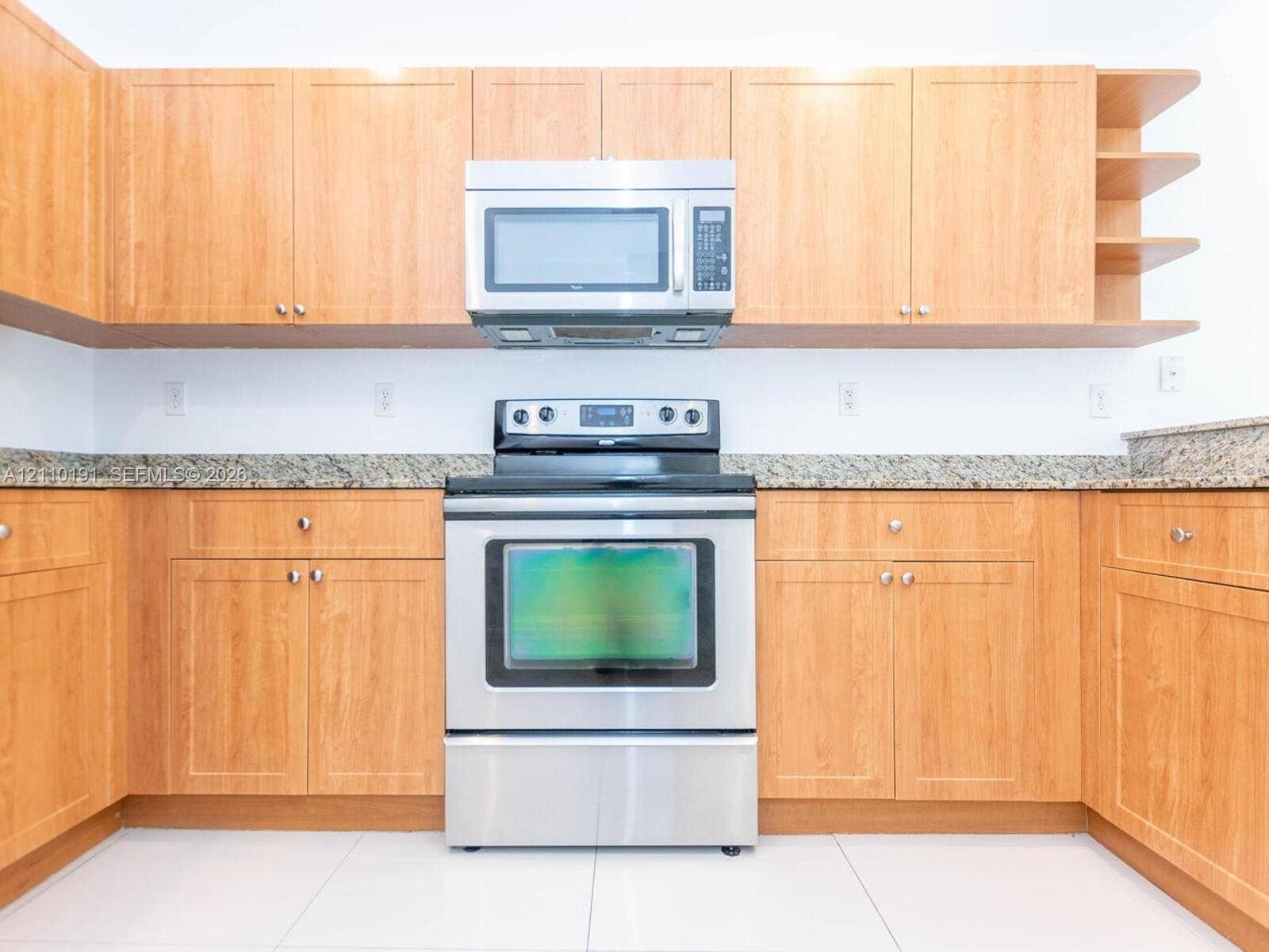 8999 NW 107 Court, #218-1, Miami, Miami, FL 33178 Kitchen featuring natural wood-finish cabinetry, stone-style countertops, stainless steel microwave, stainless steel range, and open-shelf storage