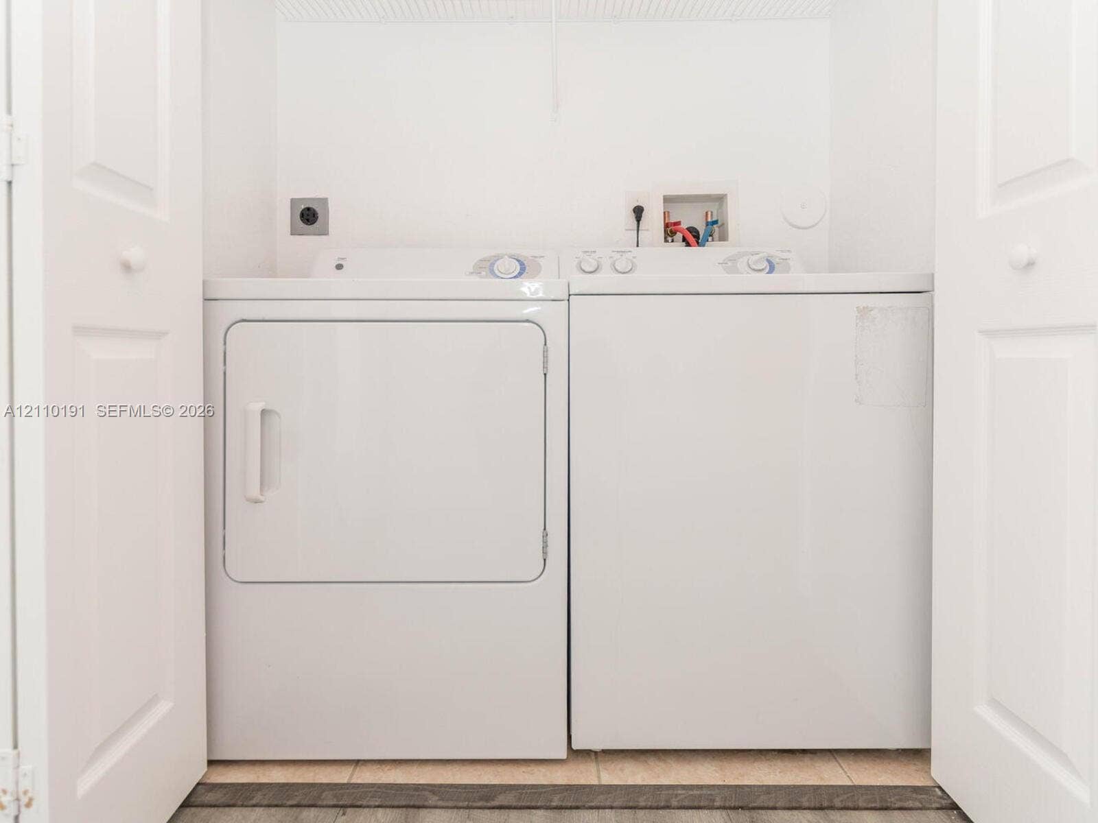 8999 NW 107 Court, #218-1, Miami, Miami, FL 33178 Laundry area featuring white paneled folding closet doors and tile flooring
