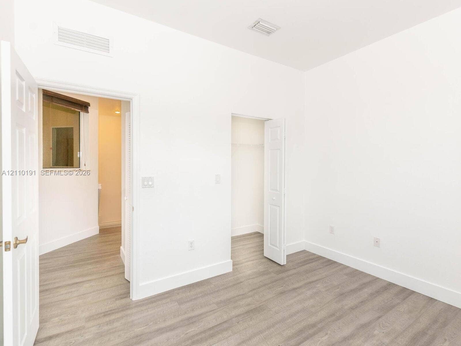 8999 NW 107 Court, #218-1, Miami, Miami, FL 33178 Interior space with wood-finish flooring, white walls, and a walk-in closet featuring built-in wire shelving