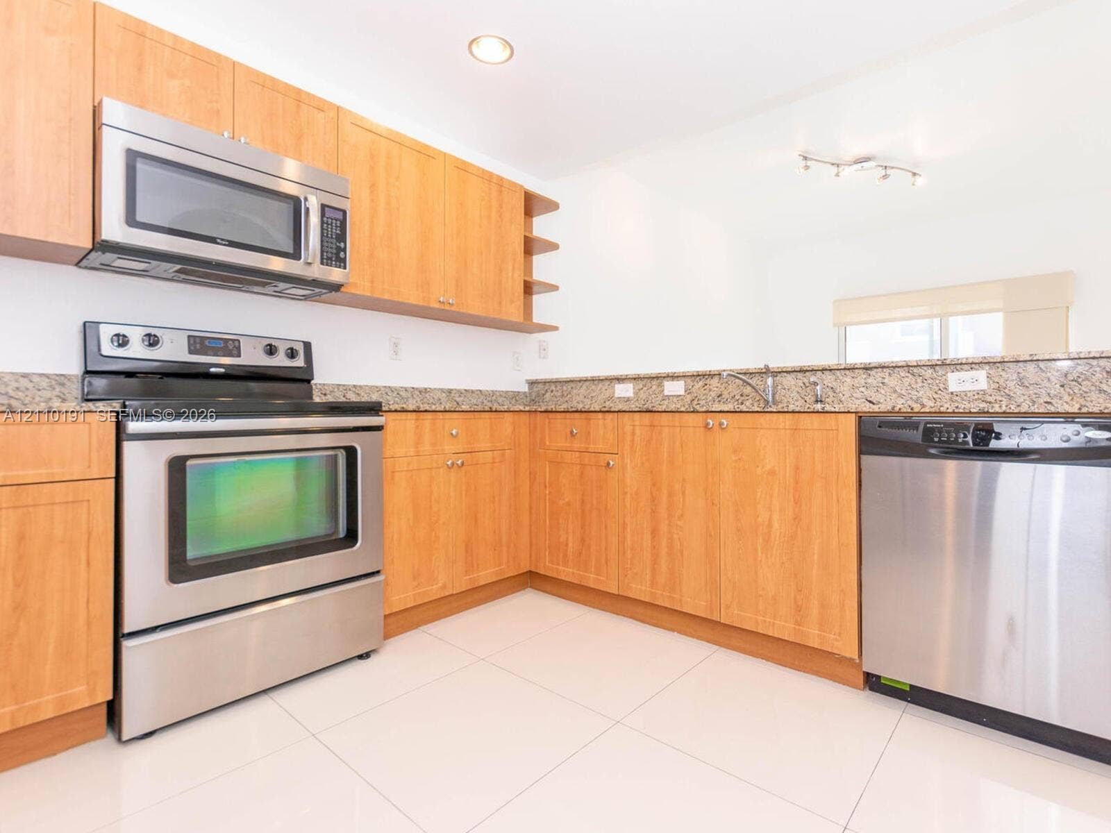 8999 NW 107 Court, #218-1, Miami, Miami, FL 33178 Kitchen featuring light wood-finish cabinetry, stone-surface countertops, stainless steel appliances, and tile flooring