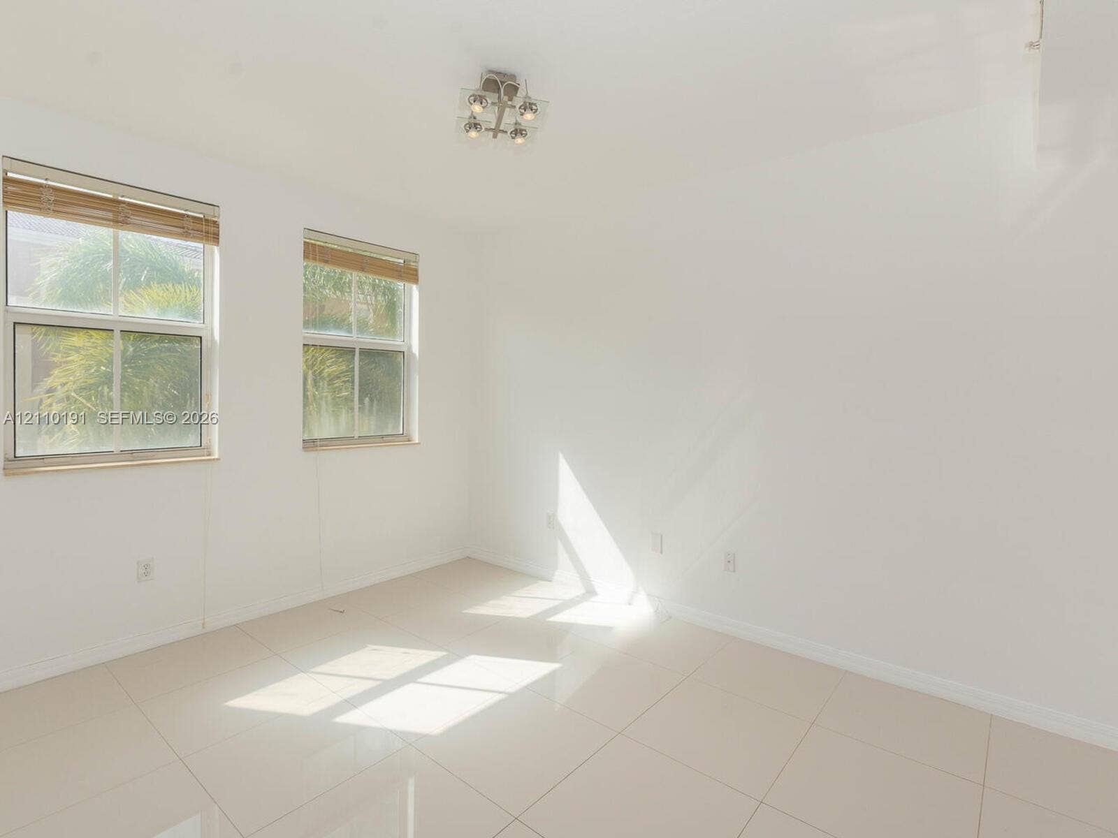 8999 NW 107 Court, #218-1, Miami, Miami, FL 33178 Neutral-toned tile flooring, dual double-hung windows with integrated blinds, and a multi-light flush-mount ceiling fixture