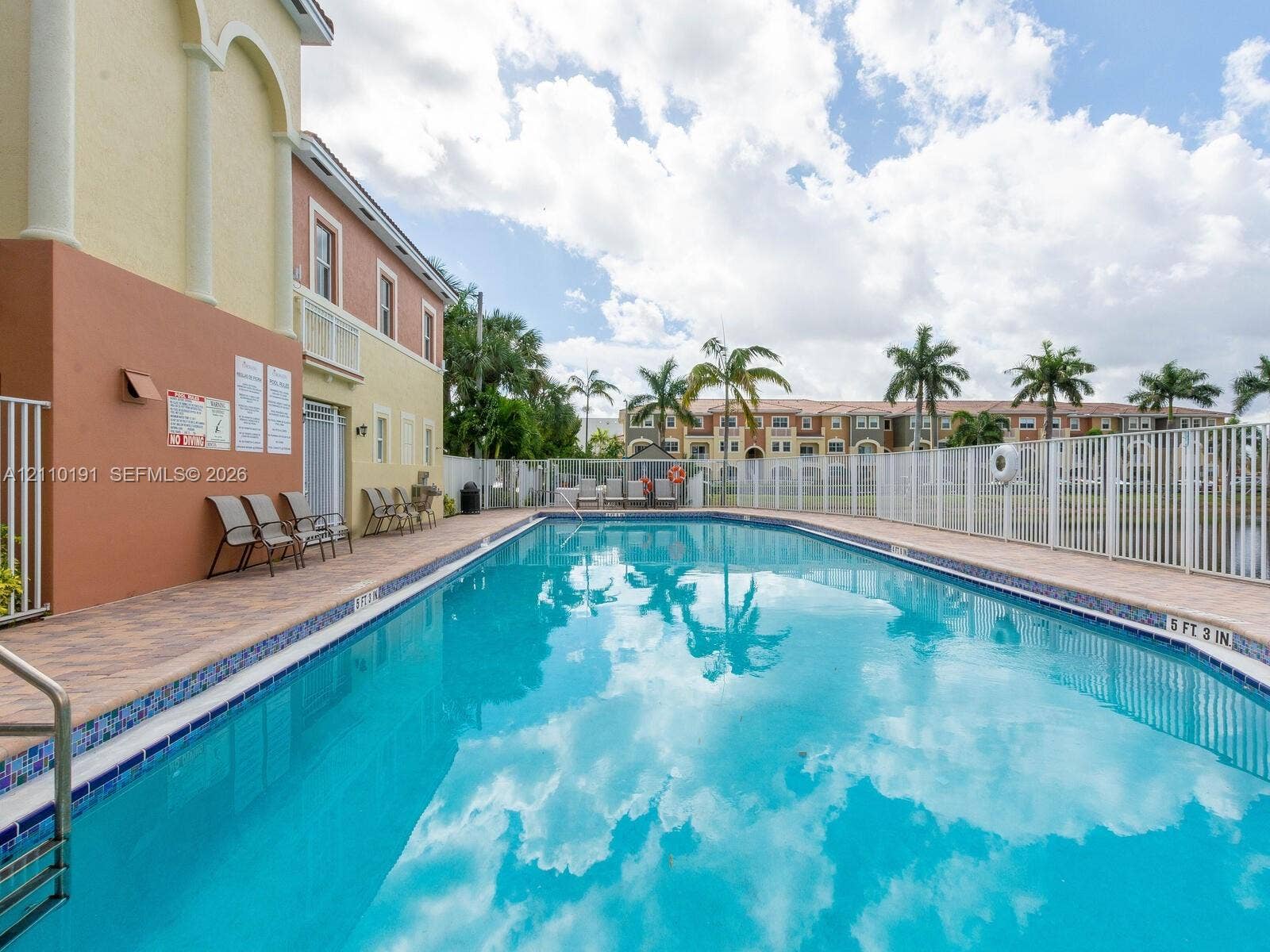8999 NW 107 Court, #218-1, Miami, Miami, FL 33178 In-ground swimming pool featuring a tile border, metal perimeter fencing, and concrete paver deck