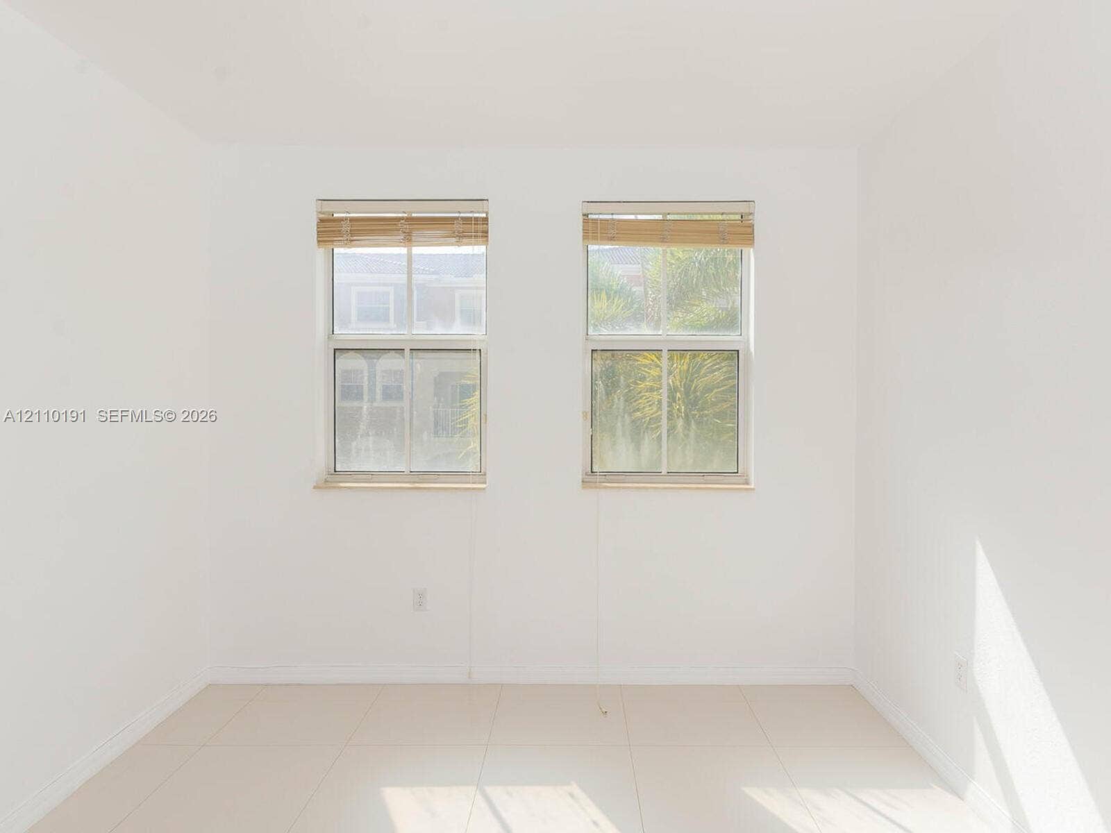 8999 NW 107 Court, #218-1, Miami, Miami, FL 33178 Neutral-toned walls paired with large-format floor tile, complemented by two double-hung windows featuring wood-finish blinds