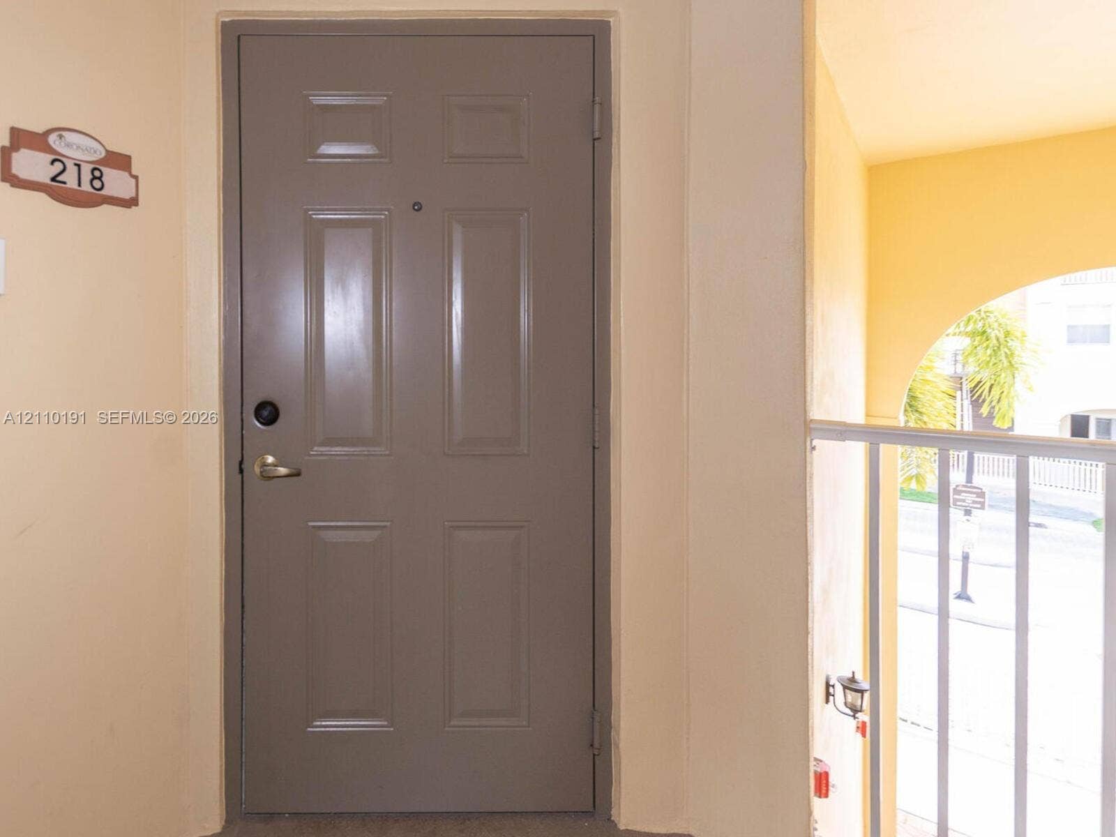 8999 NW 107 Court, #218-1, Miami, Miami, FL 33178 Solid-core, six-panel entry door featuring a matte finish lever handle, deadbolt lock, and an integrated door viewer