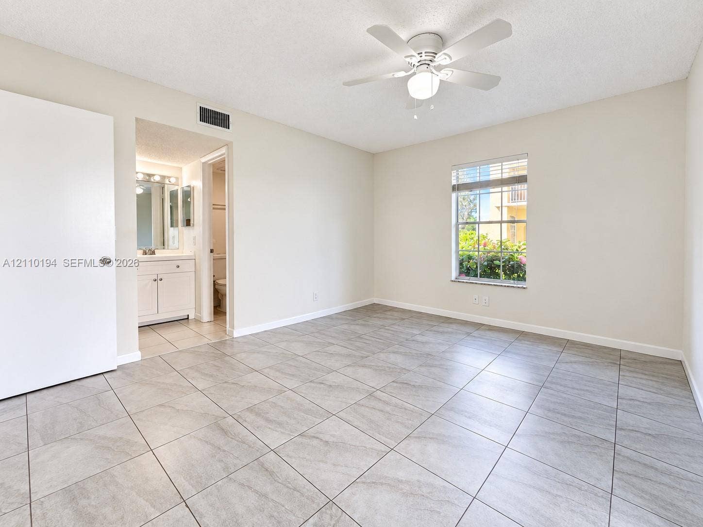 6331 La Costa Drive, #A, Boca Raton, Boca Raton, FL 33433 Room featuring large-format tile flooring, a multi-blade ceiling fan with an integrated light fixture, a single-hung window, and a white interior door