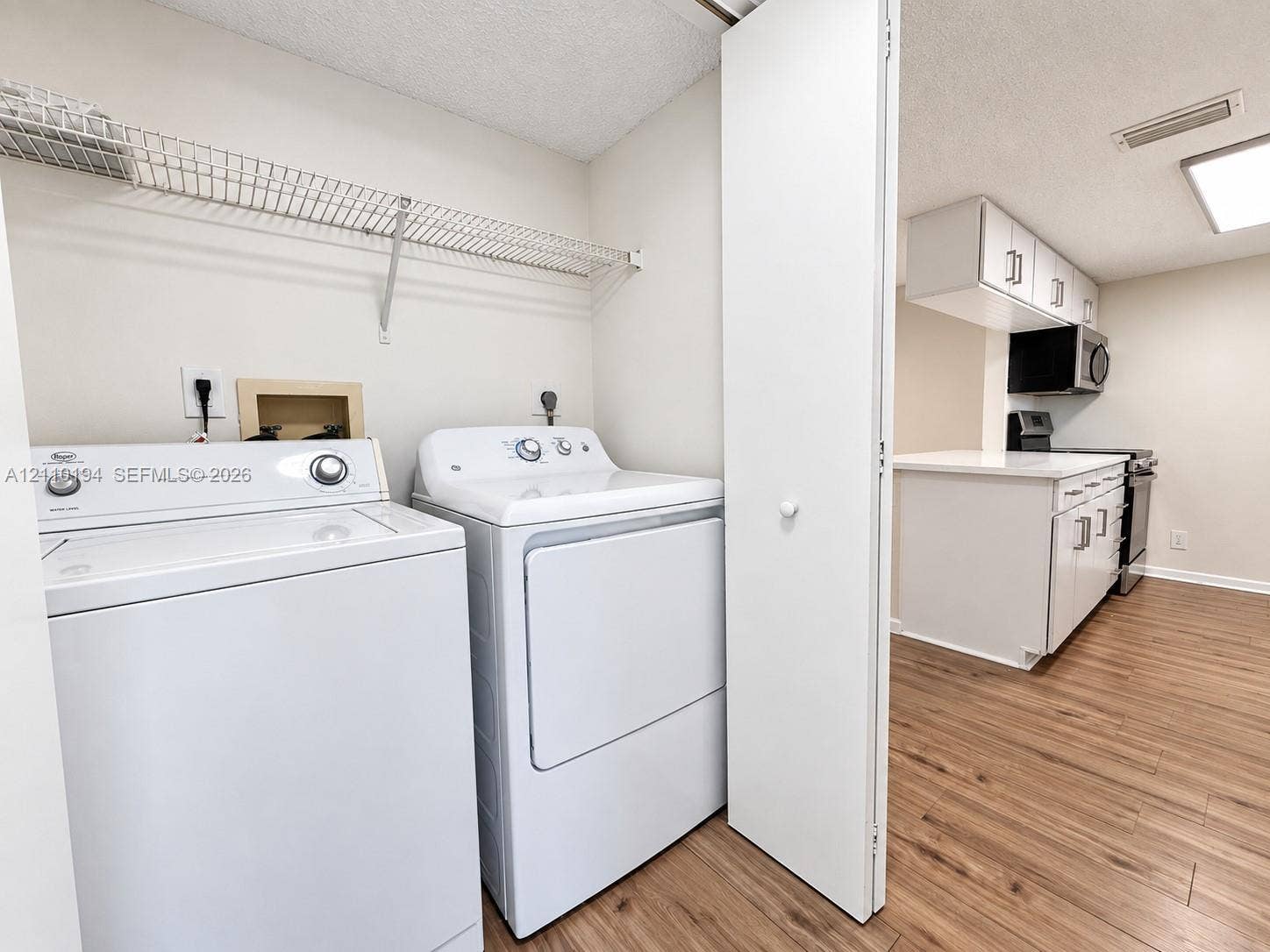 6331 La Costa Drive, #A, Boca Raton, Boca Raton, FL 33433 Laundry area featuring wire shelving and wood-finish flooring