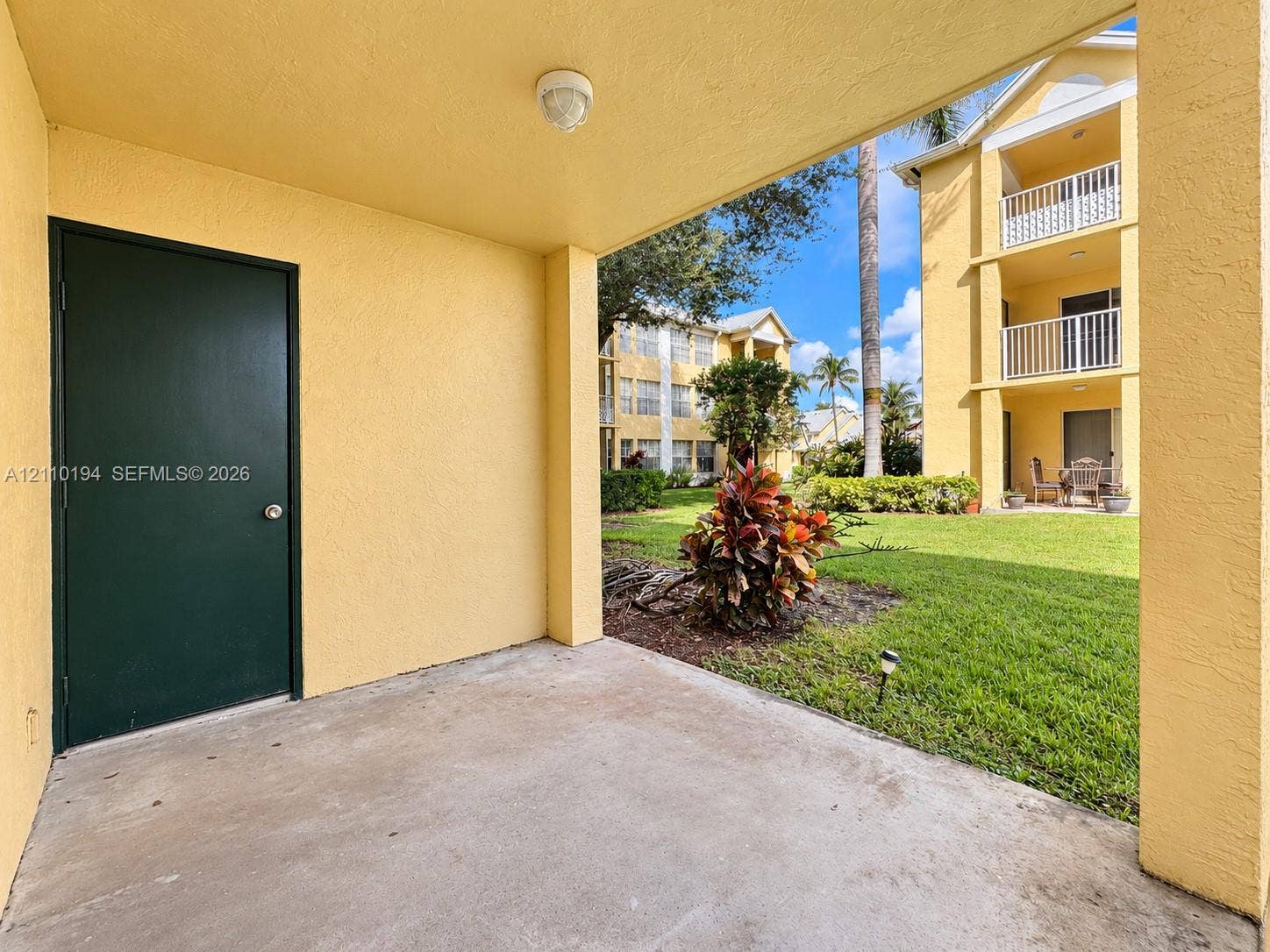 6331 La Costa Drive, #A, Boca Raton, Boca Raton, FL 33433 Covered concrete patio featuring an exterior storage closet, stucco finish, and access to a common lawn area