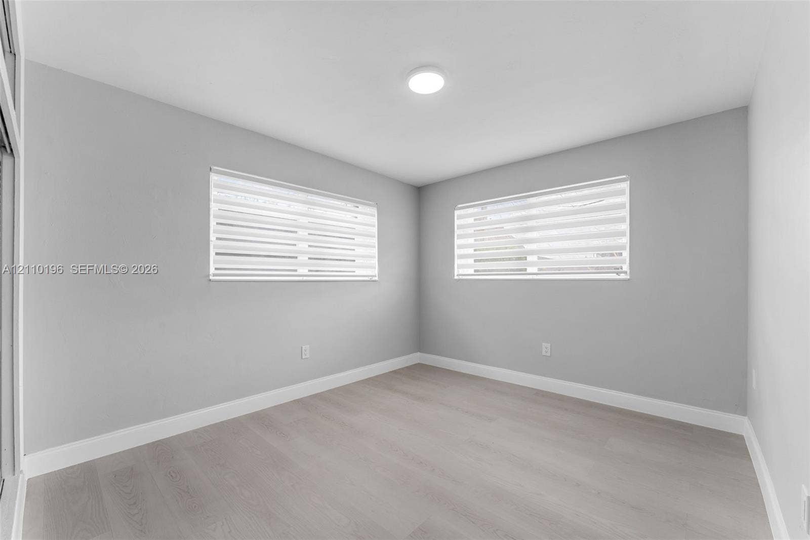 4400 SW 89th Avenue, #4400, Miami, Miami, FL 33165 Neutral-toned interior featuring wood-finish flooring, light grey walls, recessed ceiling lighting, and windows equipped with dual-layered roller shades