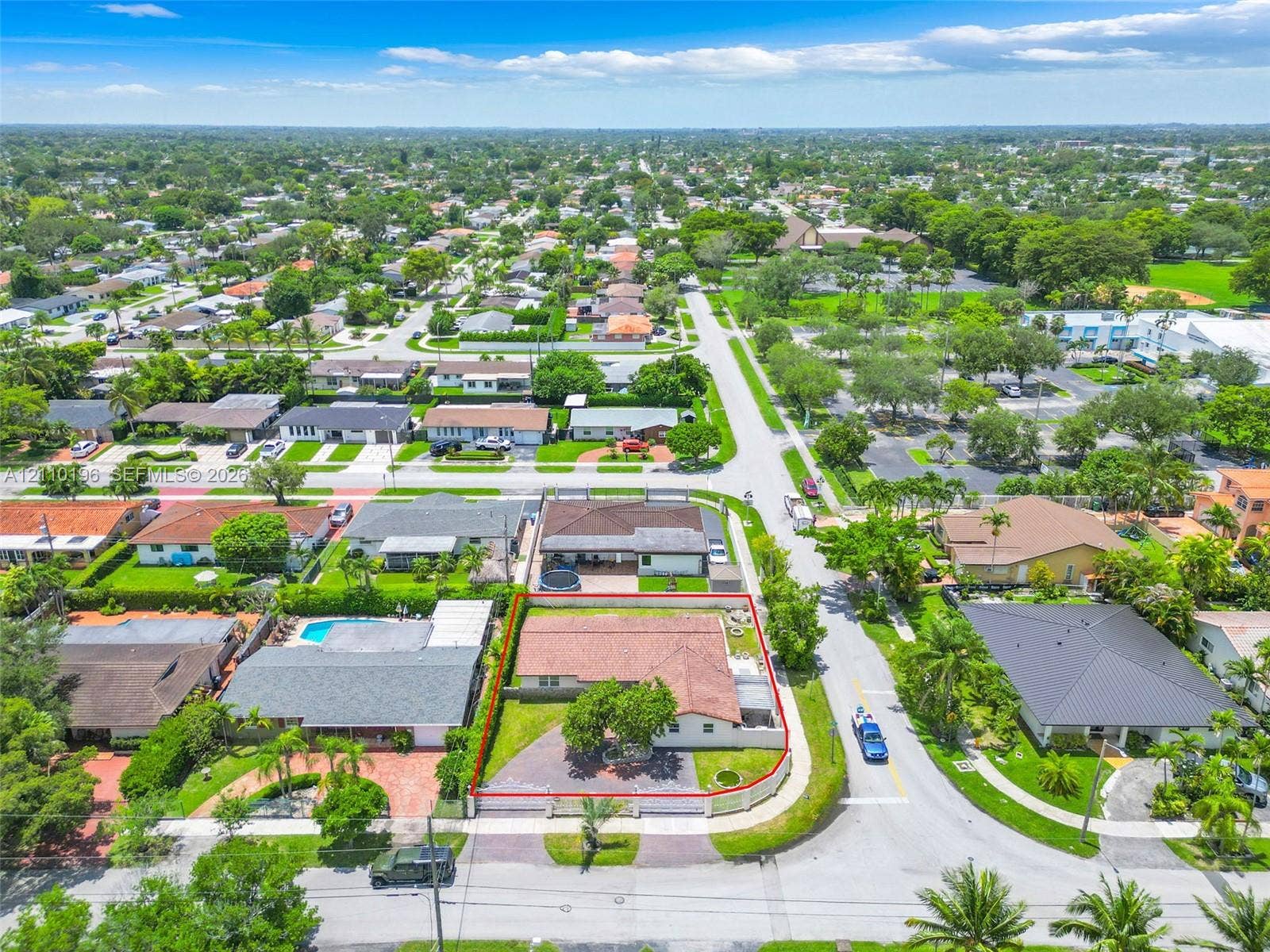 4400 SW 89th Avenue, #4400, Miami, Miami, FL 33165 Aerial perspective featuring a corner lot, paved driveway, sprawling lawn with mature landscaping, and a terracotta-tiled roof