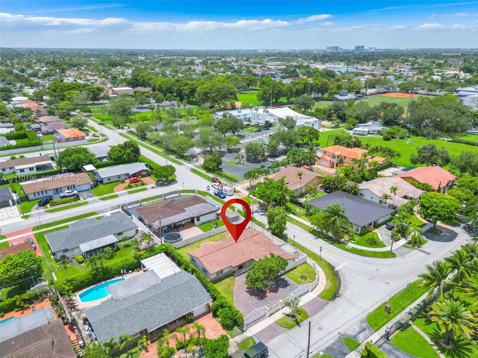 4400 SW 89th Avenue, #4400, Miami, Miami, FL 33165 Aerial perspective of a single-story residence featuring a hipped roof, paved driveway, masonry perimeter wall, and mature landscaping